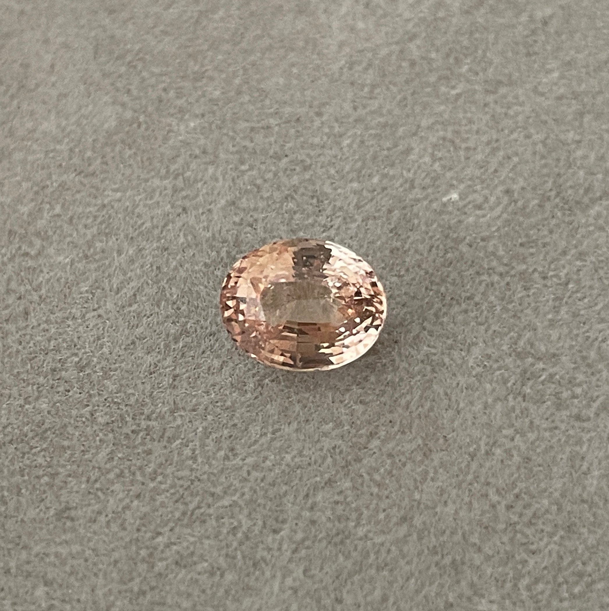 Peach sapphire oval cut in daylight
