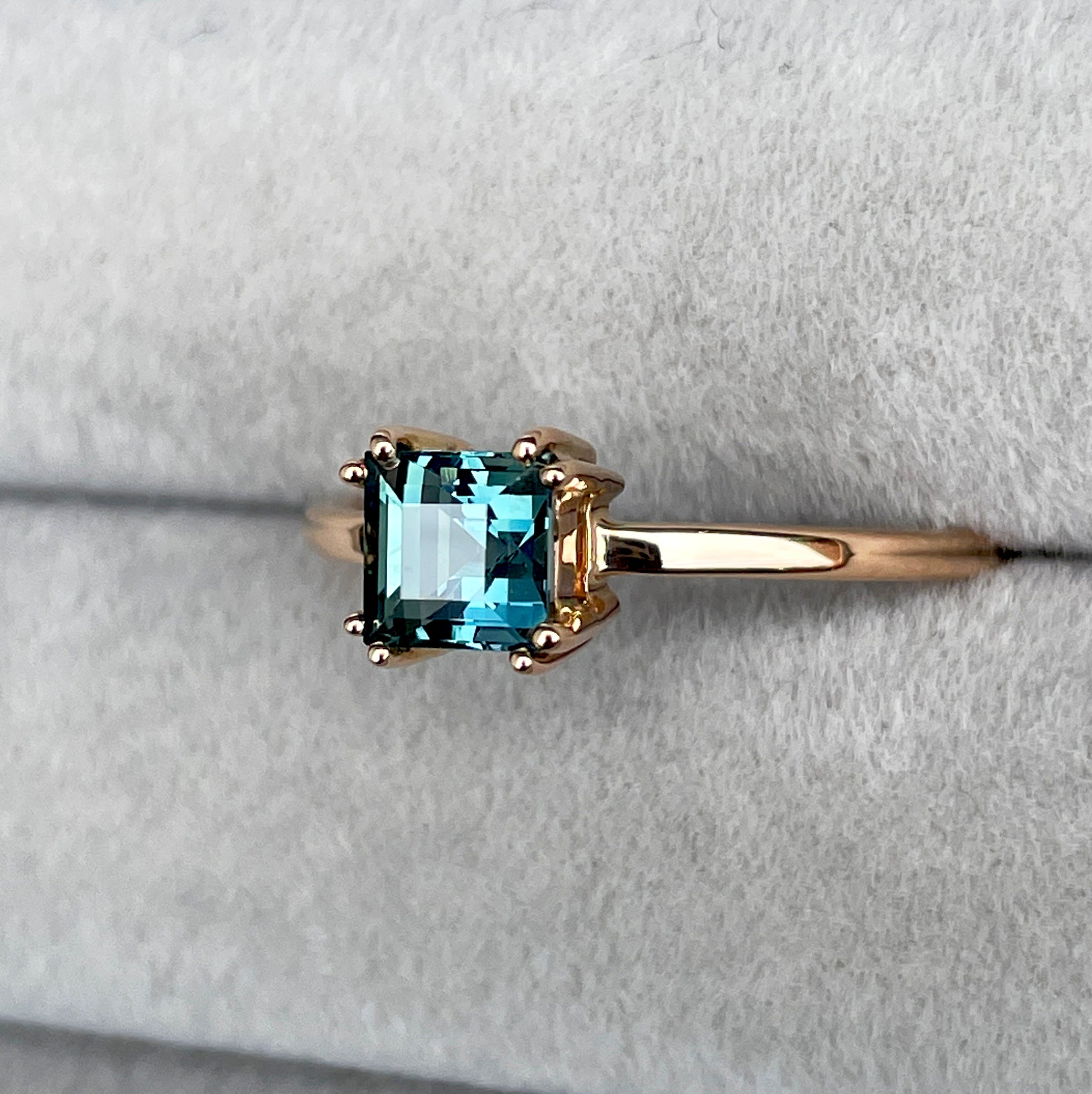 elegant ring features a 1.00 crt Natural Teal Sapphire surrounded by sparkling natural white sapphire set in a solid 18k Rose Gold ring setting. - NASHGEMS