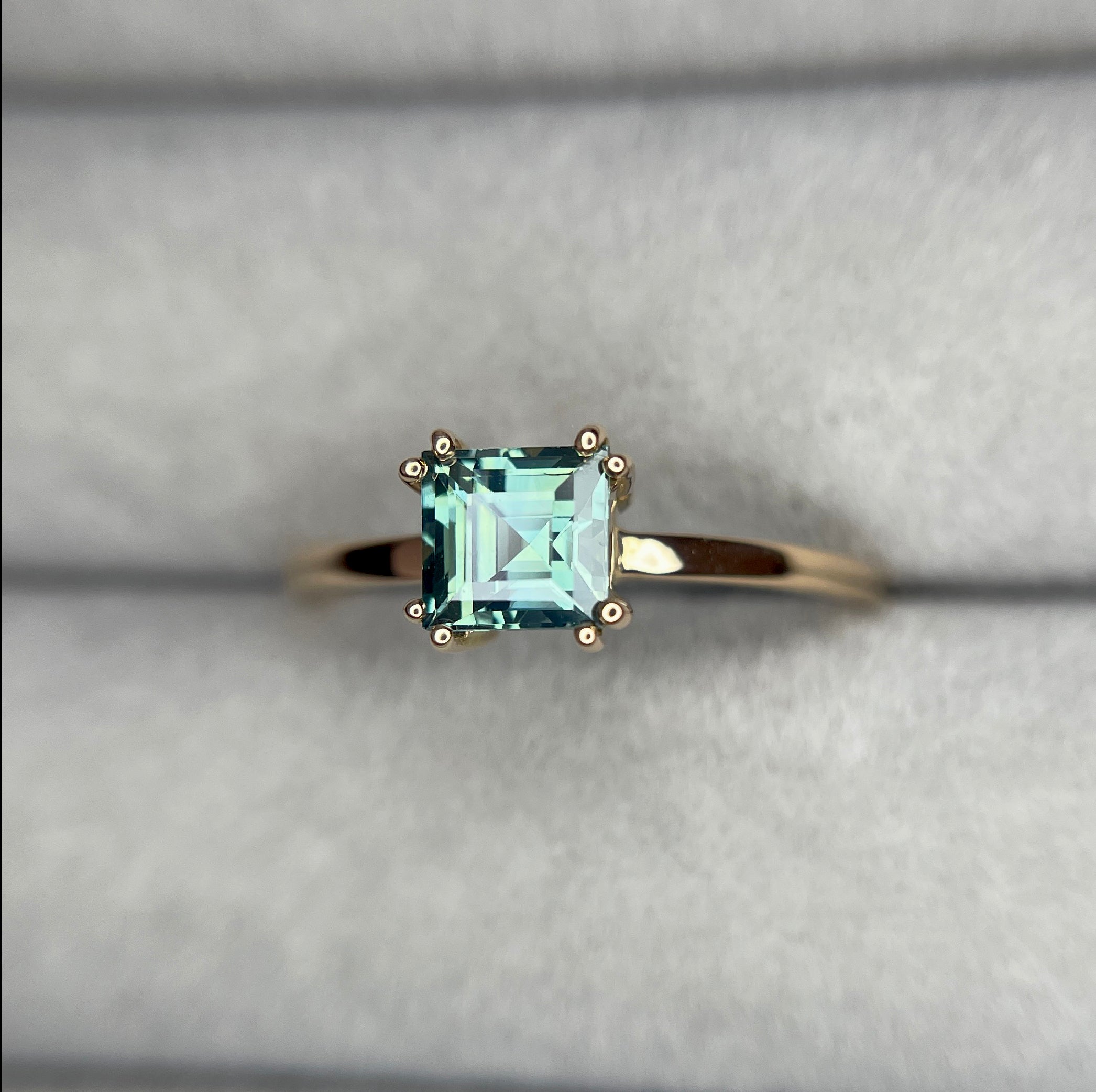 elegant ring features a 1.00 crt Natural Teal Sapphire surrounded by sparkling natural white sapphire set in a solid 18k Rose Gold ring setting. - NASHGEMS