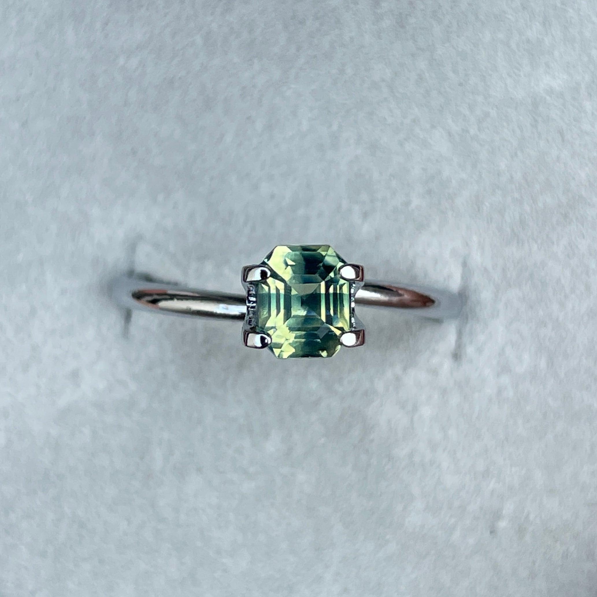 Teal bi-colored parti sapphire loose gemstone, emerald cut, 1.11 carats, vibrant green and blue hues, ideal September birthstone.