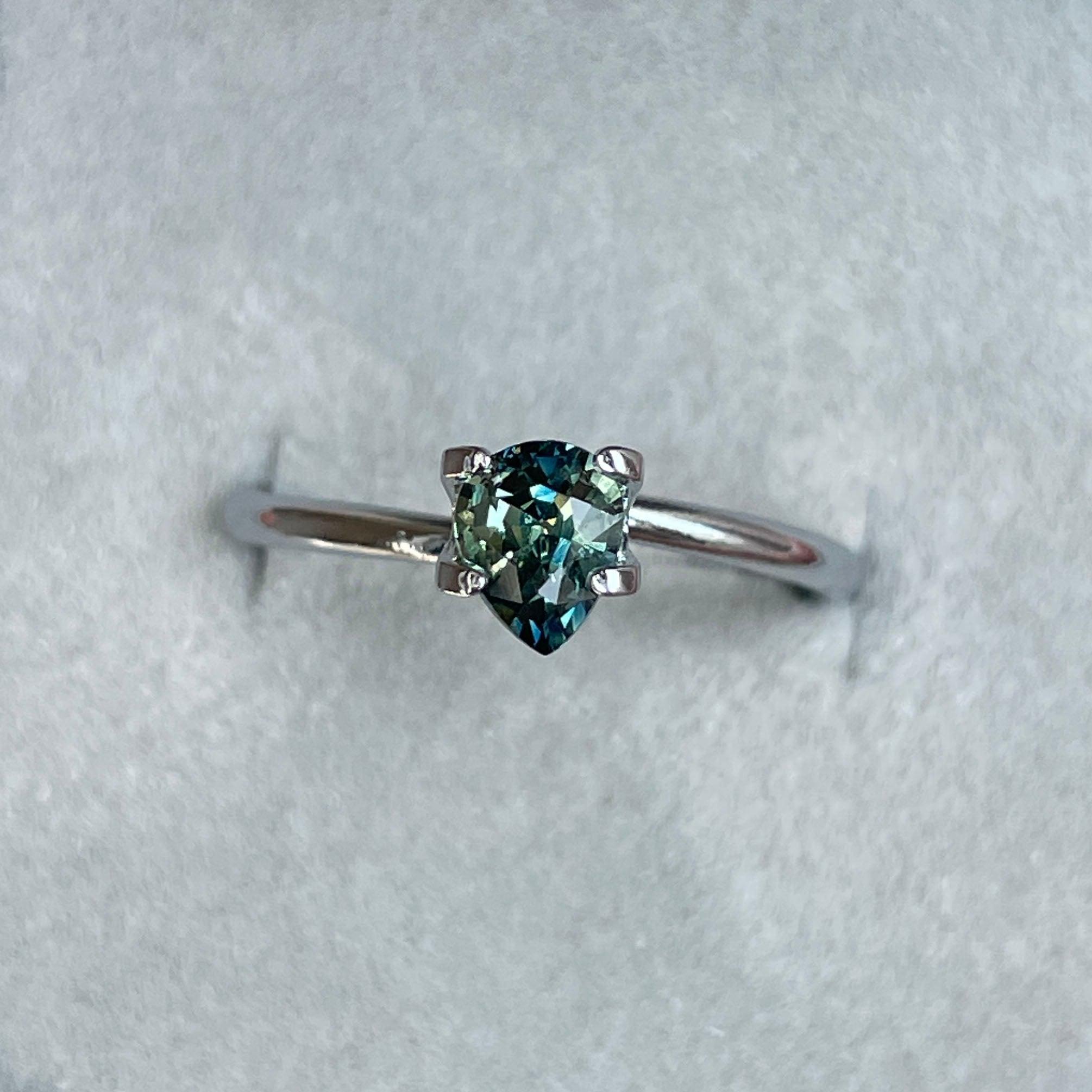 Bi-colored teal sapphire loose gemstone, 0.83 carats, with vibrant green and blue hues, perfect for September birthstone jewelry.