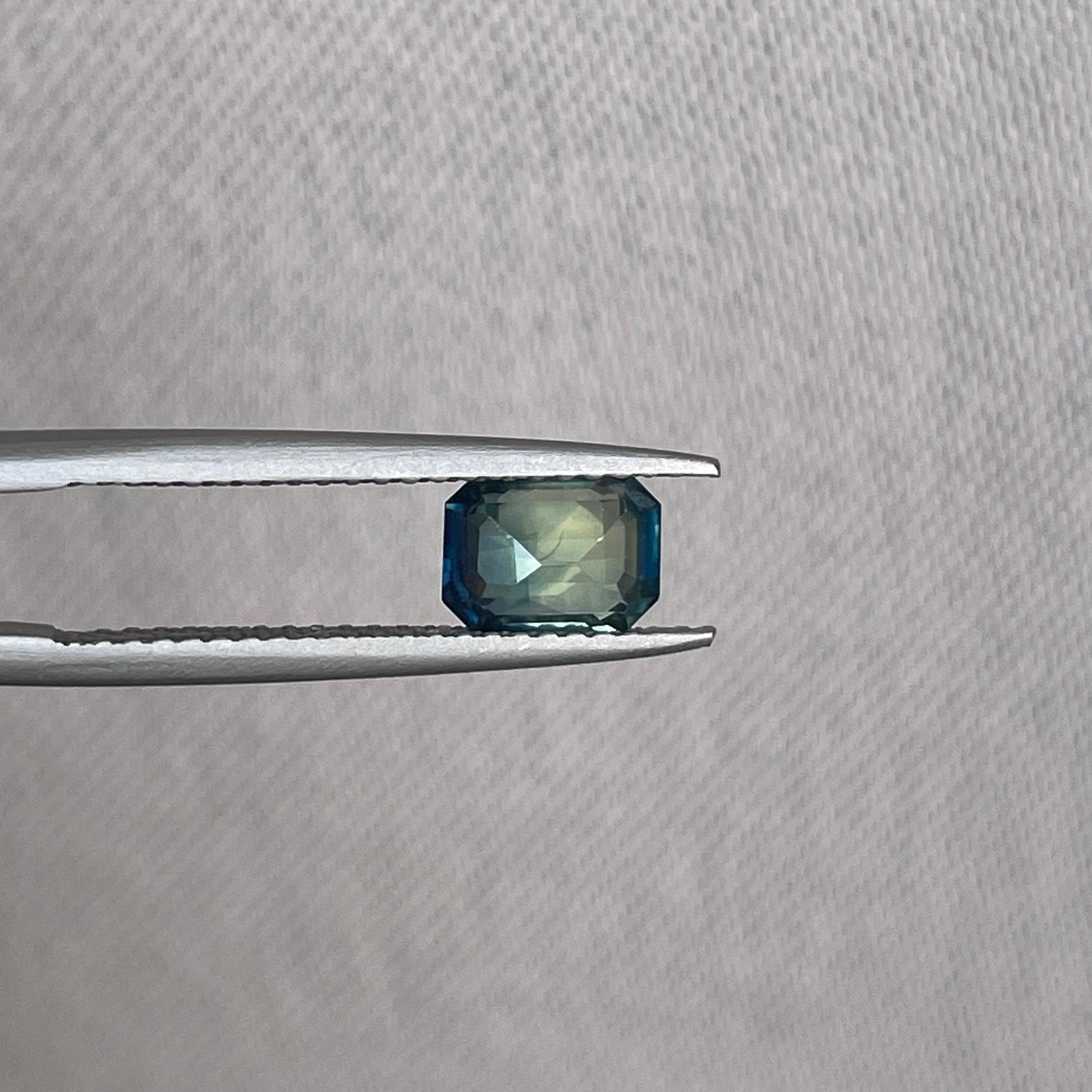 Teal bi-colored parti sapphire loose gemstone from NASHGEMS, 1.09 carats, featuring vibrant teal green and sapphire hues for September birthstone.
