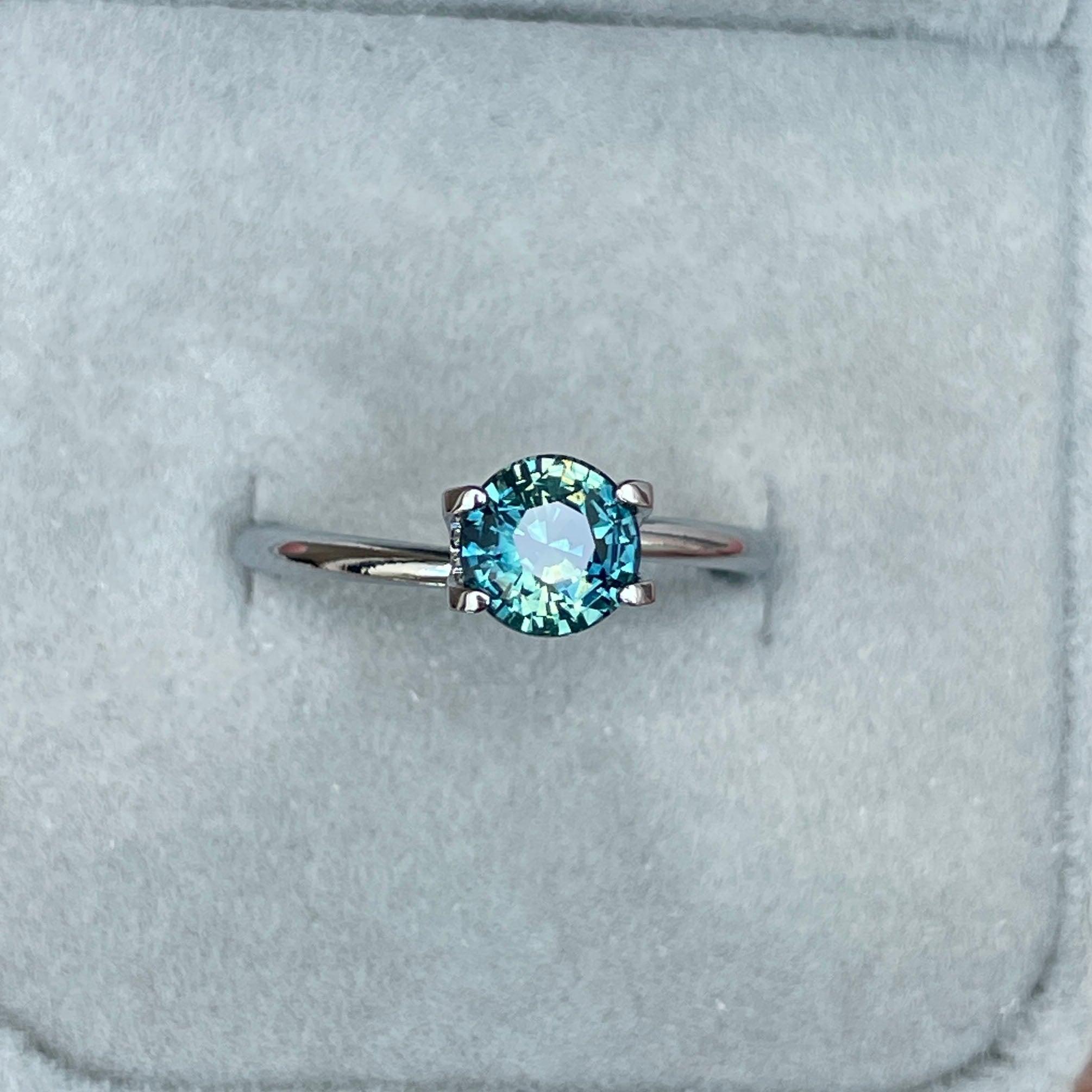 Bi-colored teal sapphire gemstone, 1.31 carats, round shape, loose parti sapphire with vibrant green and blue hues from NASHGEMS.