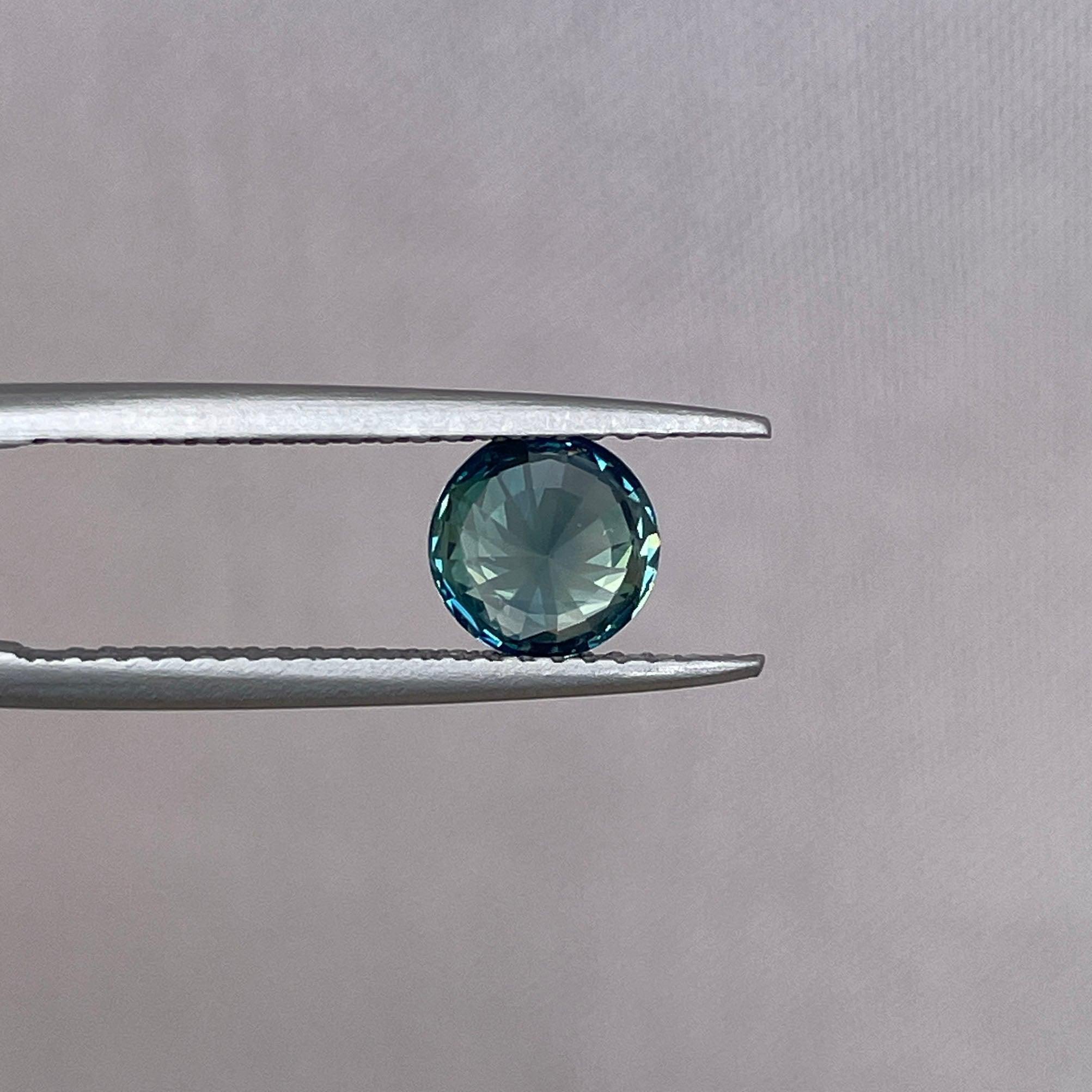 Teal bi-colored parti sapphire gemstone, 1.31 carats, round shape, NASHGEMS, perfect for September birthstone jewelry.