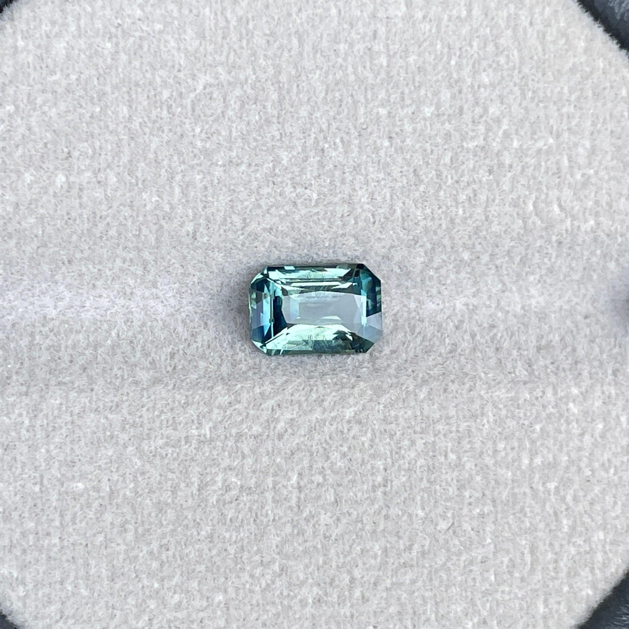 Bi-colored teal sapphire gemstone with emerald cut, 1.54 carats, from NASHGEMS, showcasing vibrant green and blue hues for September birthstone.