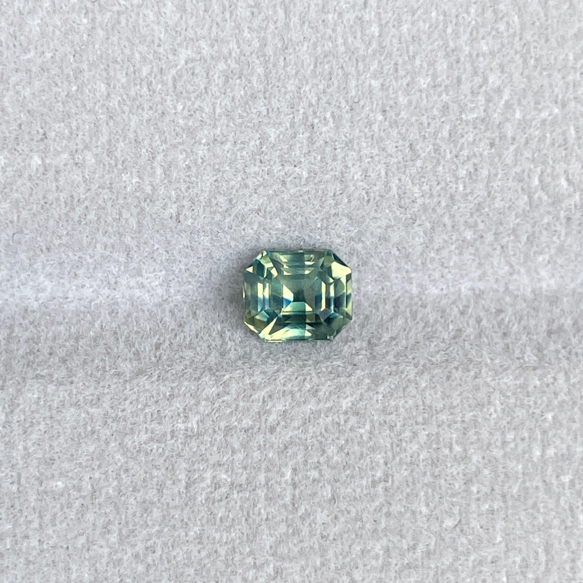 Bi-colored teal sapphire gemstone, 1.11 carats, emerald cut, loose parti sapphire in green and blue shades, perfect for September birthstone.