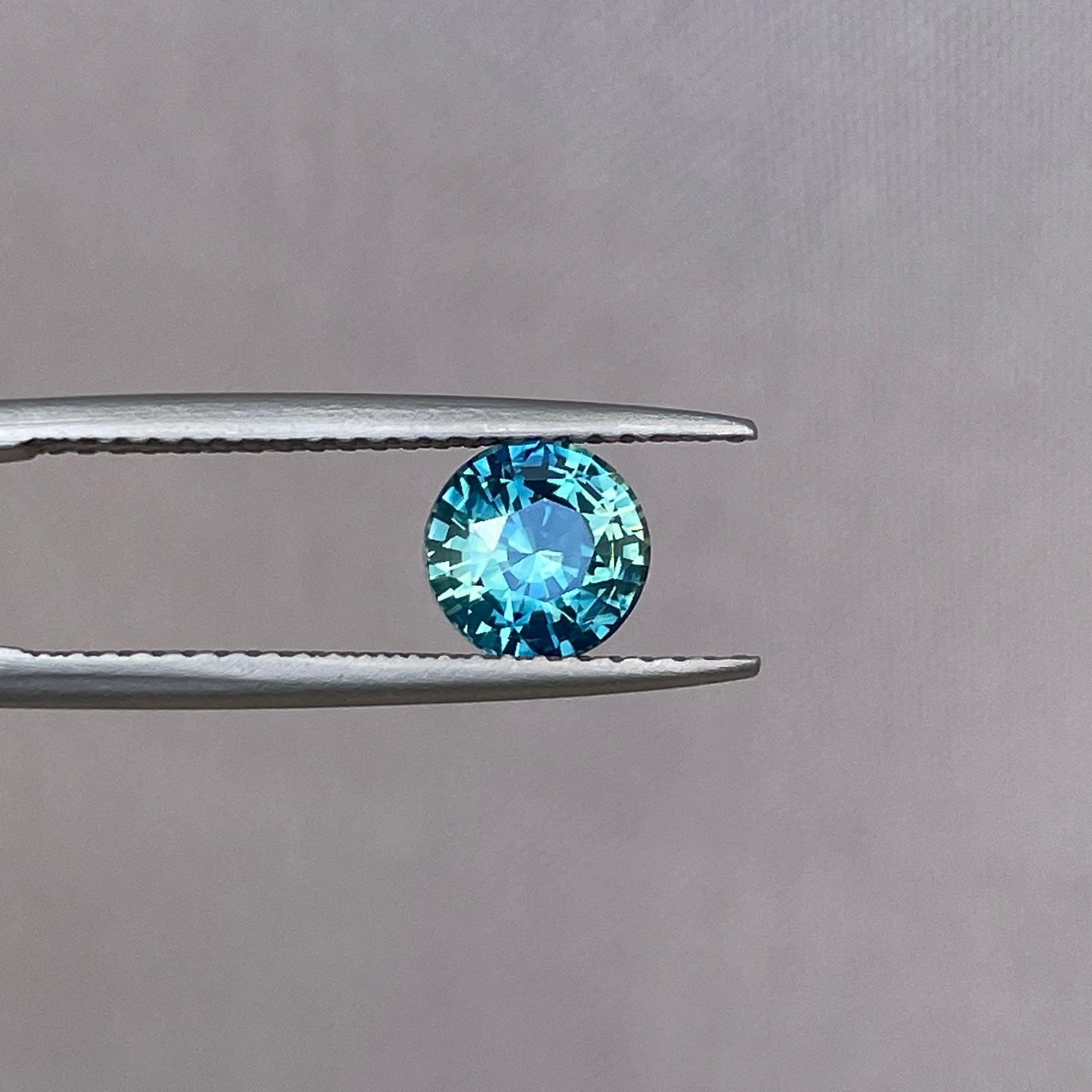 Bi-colored teal sapphire gemstone, 1.31 ct round loose parti sapphire in green and blue, birthstone for September, from NASHGEMS.