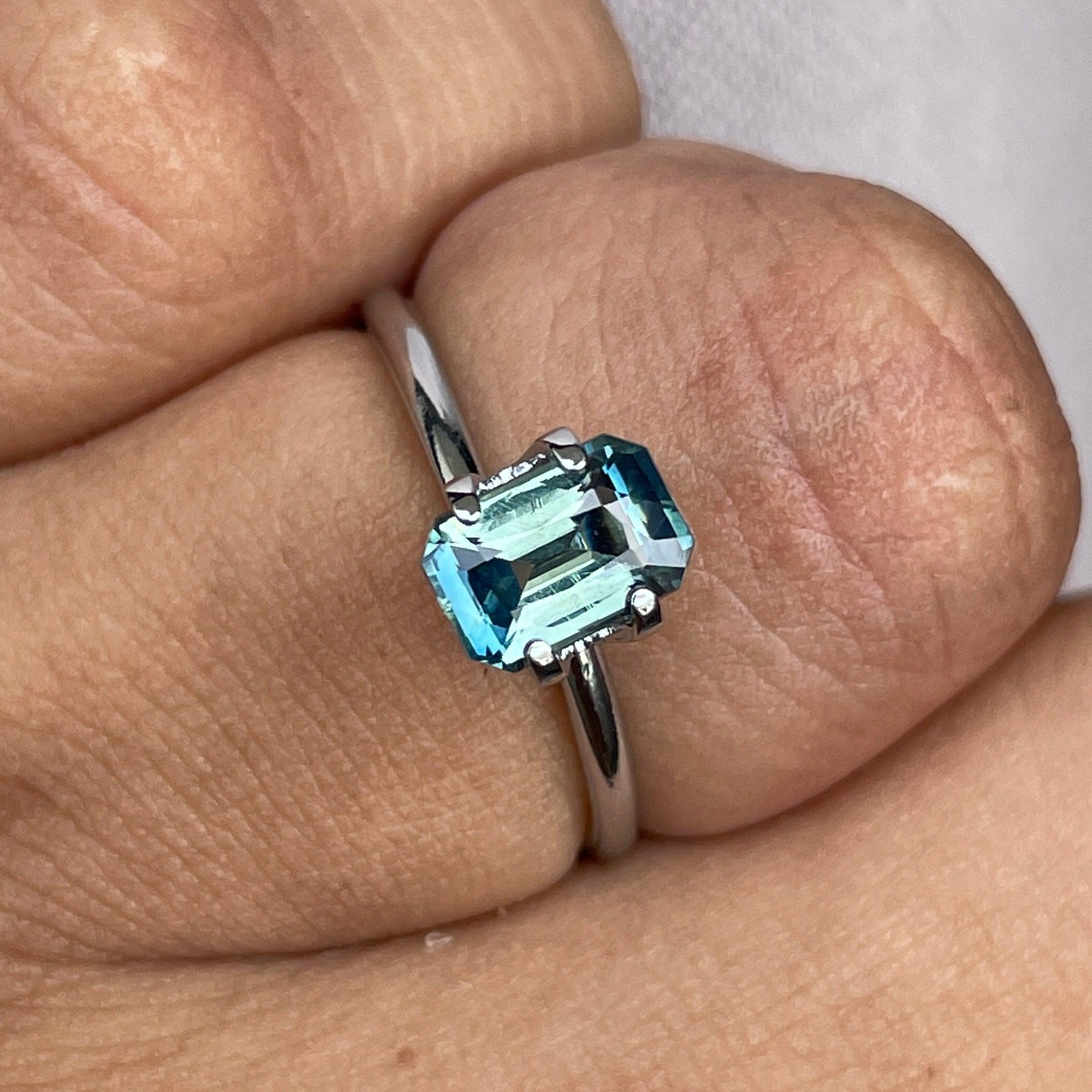 Teal bi-colored parti sapphire gemstone, 1.54 carats, emerald cut, loose precious stone from NASHGEMS with vibrant green and blue hues.