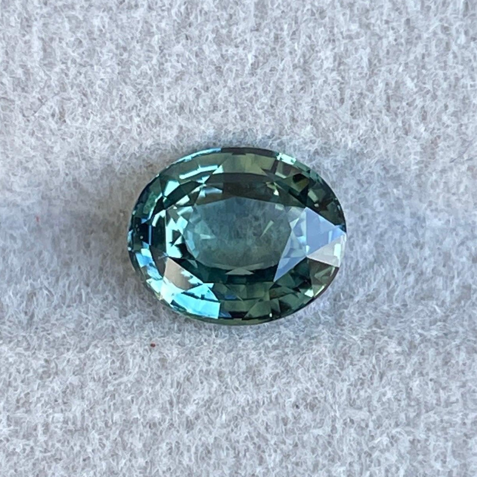 Bague d'anniversaire en saphir sarcelle avec un saphir bleu-vert ovale de 2,04 carats, créée par NASHGEMS pour des bijoux de fiançailles uniques.