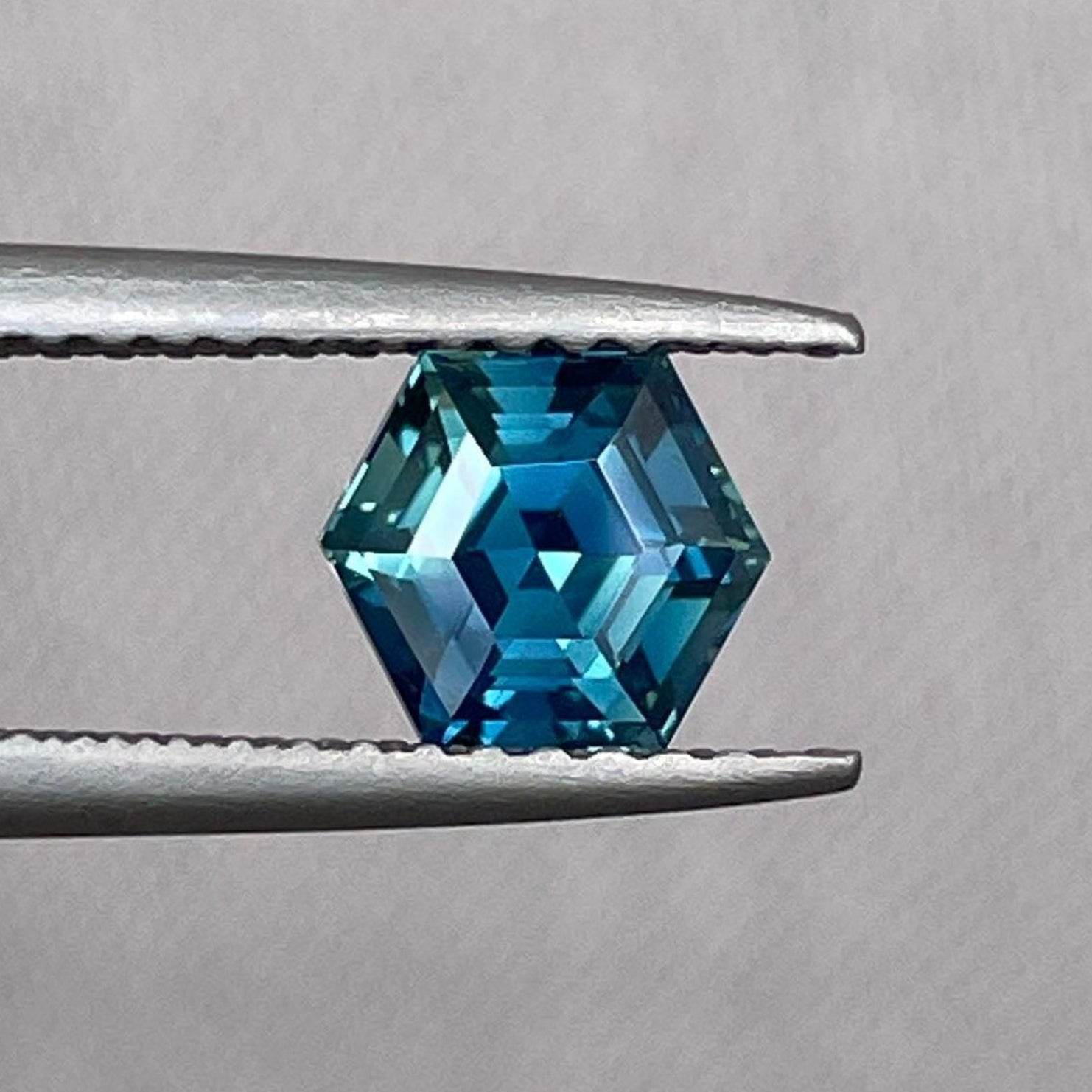 Saphir bleu-vert sarcelle en forme d'hexagone, pierre précieuse détachée de 1,24 ct, pour la création de bijoux, présentant une couleur vibrante et une surface polie.
