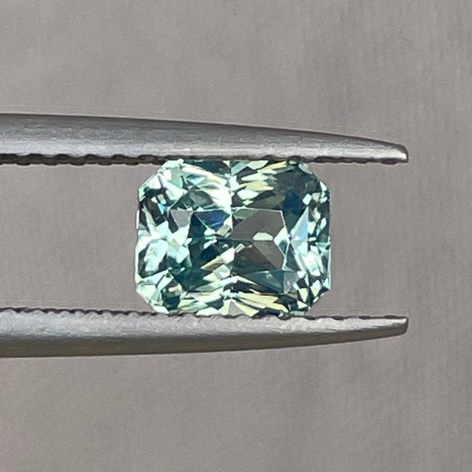 Saphir teal bleu verdâtre taille radiant, 1,26 carats, présentant une couleur vibrante et une grande clarté, de NASHGEMS.