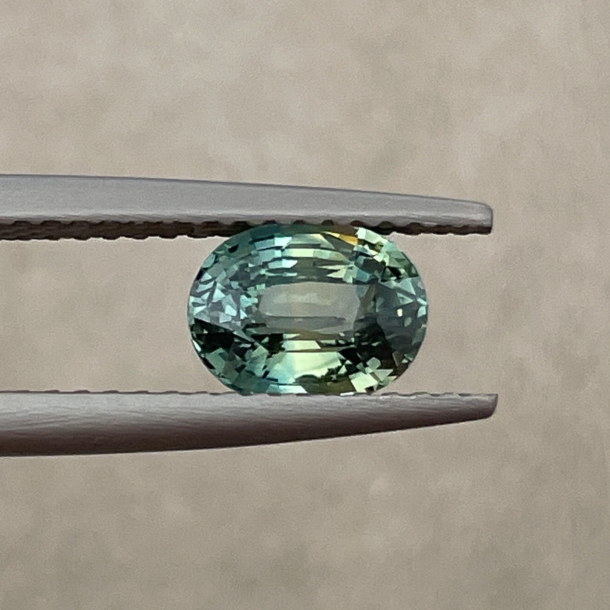 Teal green sapphire loose oval cut 1.45 ct from NASHGEMS, showcasing vibrant color and clarity for jewelry creation.