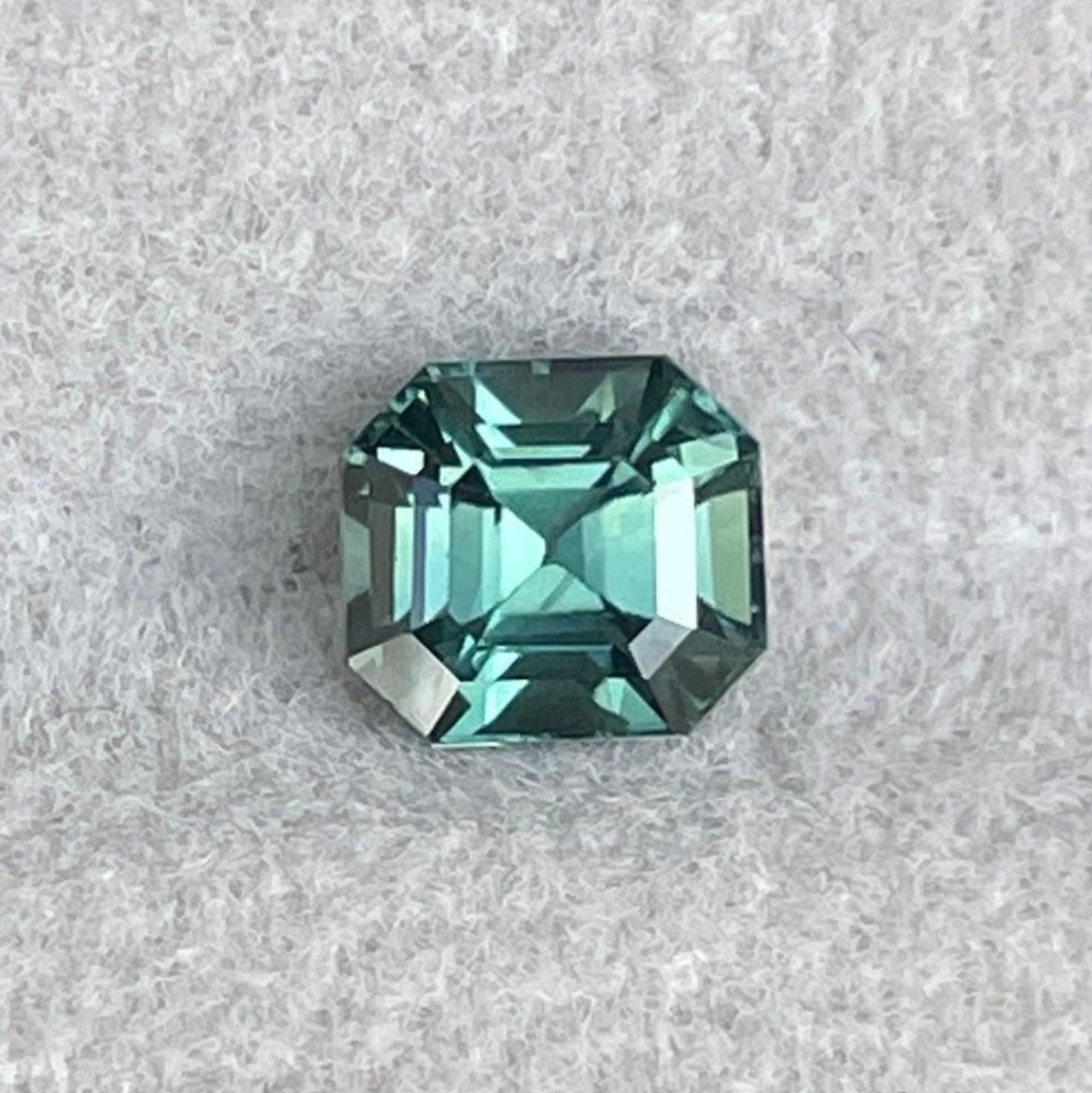 Pierre précieuse saphir vert naturel de NASHGEMS, saphir bleu sarcelle de 1,10 ct avec des nuances de vert foncé et clair en taille émeraude.