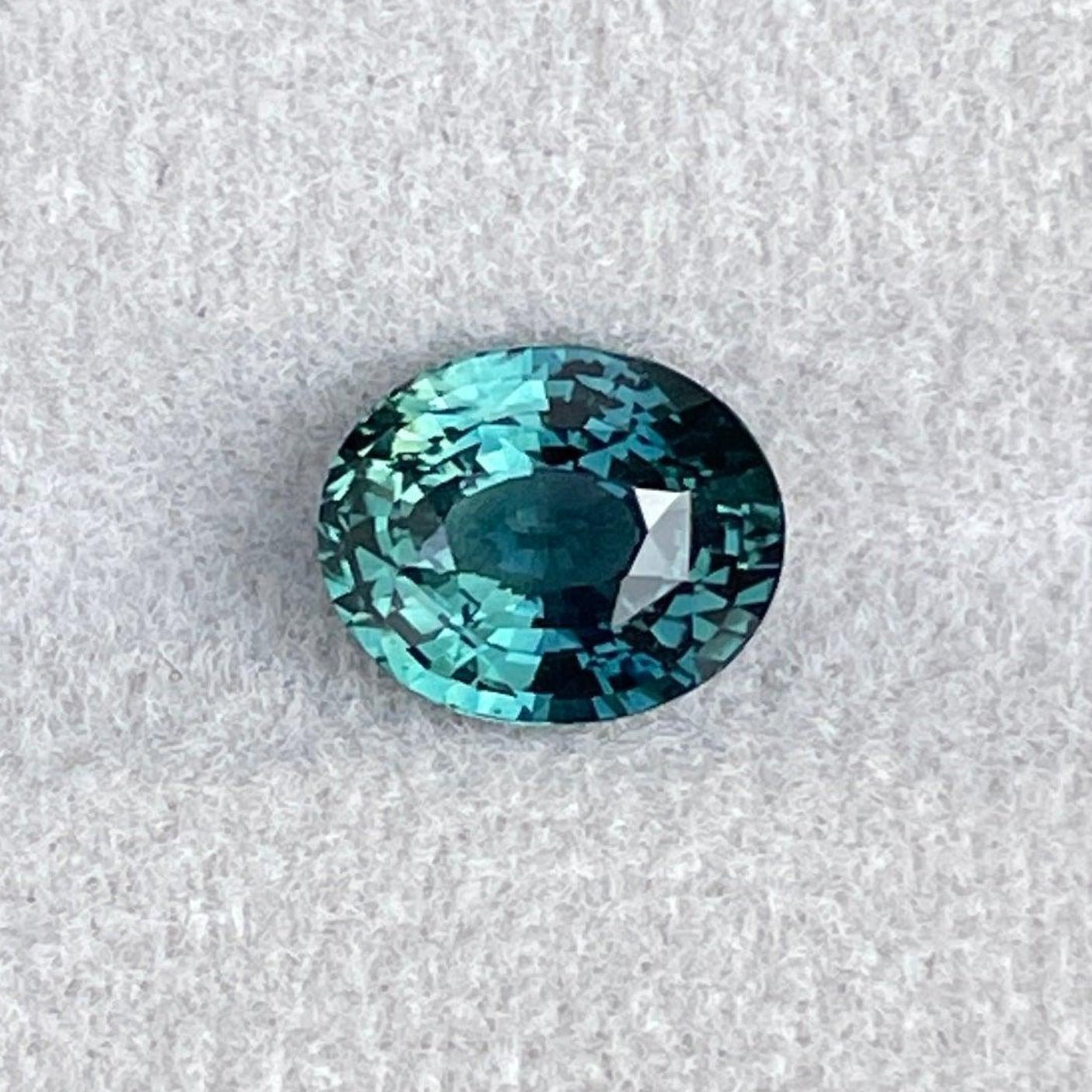 Pierre précieuse saphir teal taille ovale en couleur parti bleu-vert, 2,54 ct de NASHGEMS, mettant en valeur la beauté vibrante et naturelle de la pierre précieuse.