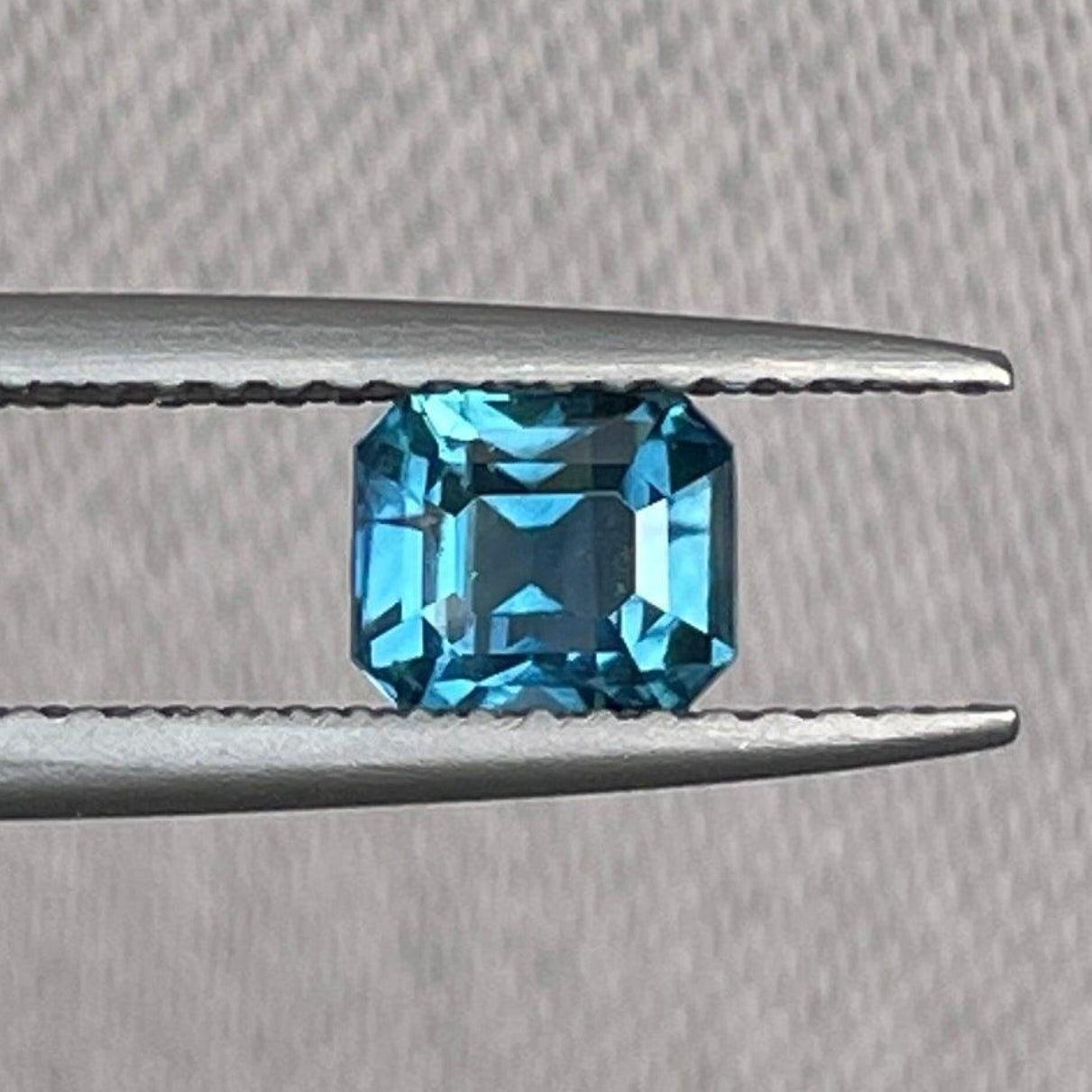 Saphir sarcelle taille émeraude, 1,03 carats, de NASHGEMS, présenté comme pierre précieuse pour bagues de fiançailles et bijoux personnalisés.