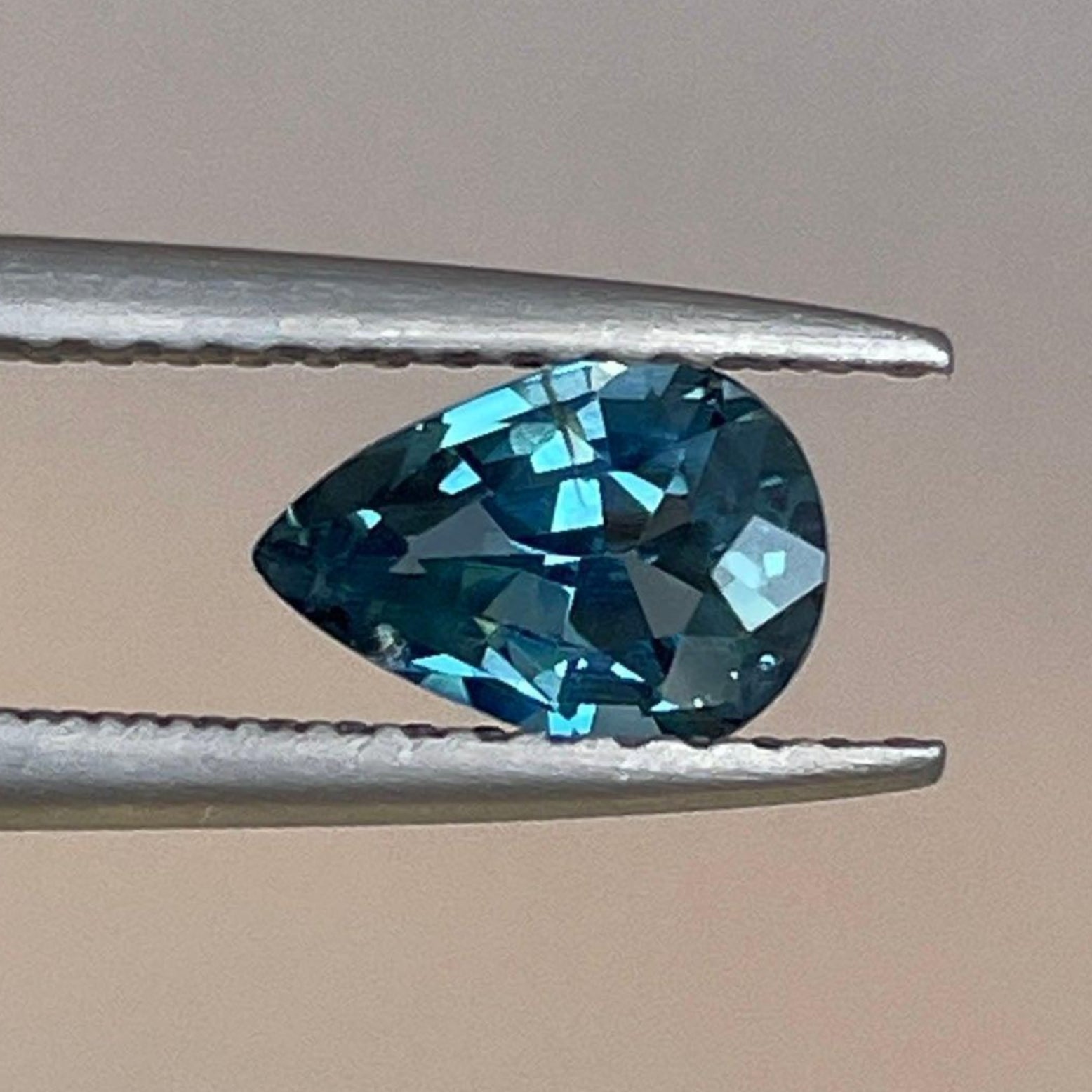 Pierre précieuse saphir poire couleur sarcelle, 0,87 carat, de NASHGEMS, mettant en valeur sa couleur sarcelle vibrante et sa taille polie.