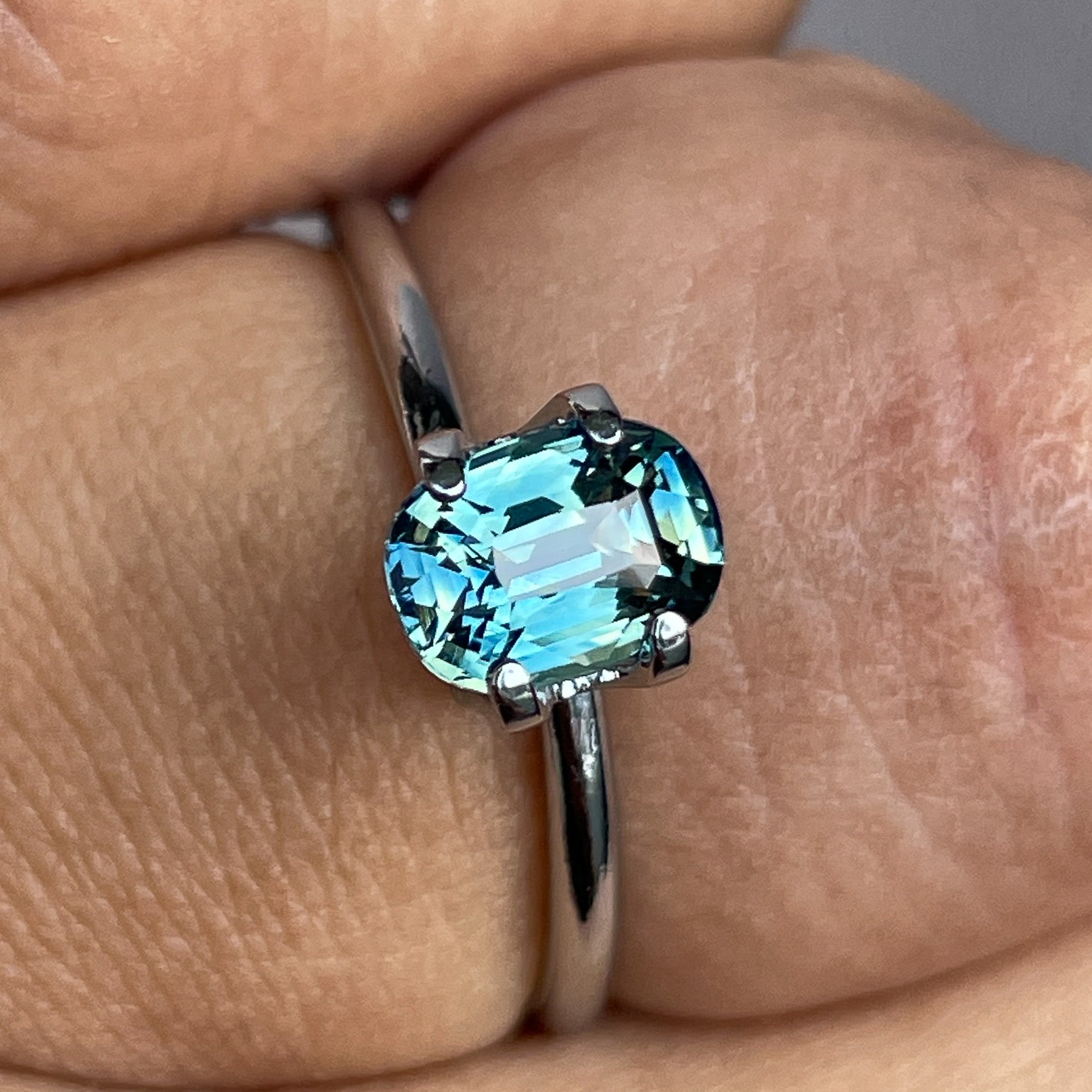Natural teal sapphire 1.36 Ct cushion cut by NASHGEMS, showcasing vibrant blue-green tones, perfect for engagement or custom jewelry.