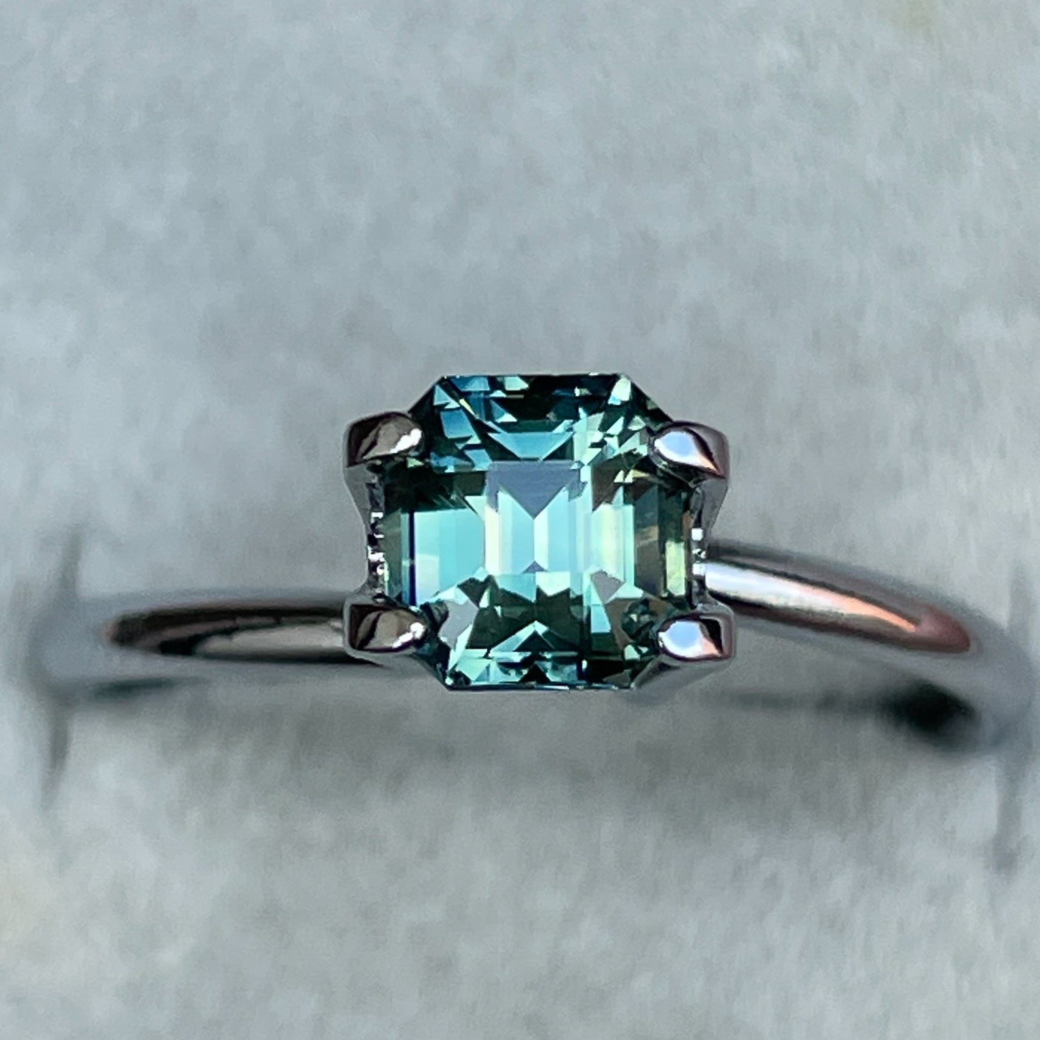 Natural teal green sapphire, 1.36 Ct emerald cut, loose gemstone by NASHGEMS, ideal for engagement rings or custom jewelry.