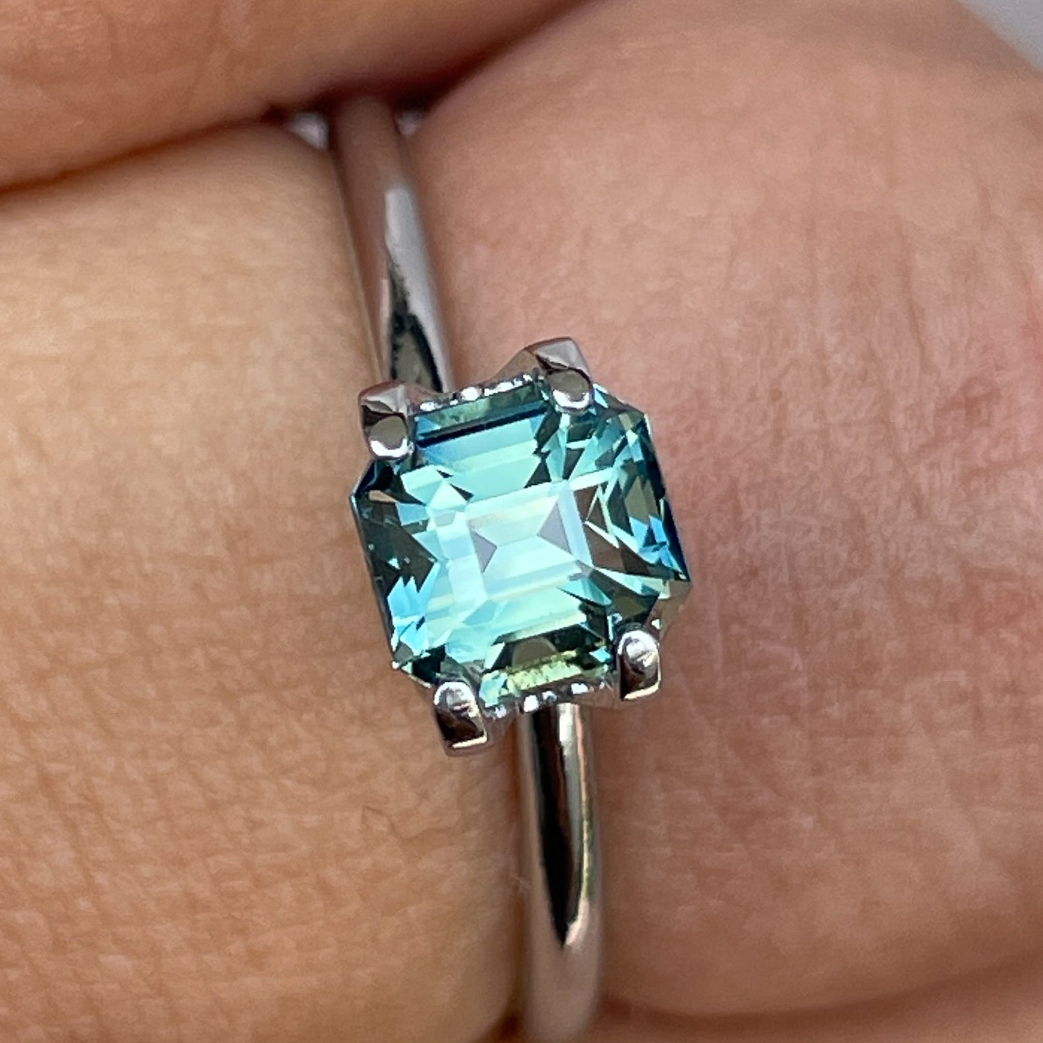 Natural teal green sapphire 1.36 Ct emerald cut by NASHGEMS, showcasing vibrant blue-green hues, perfect for jewelry or engagement rings.