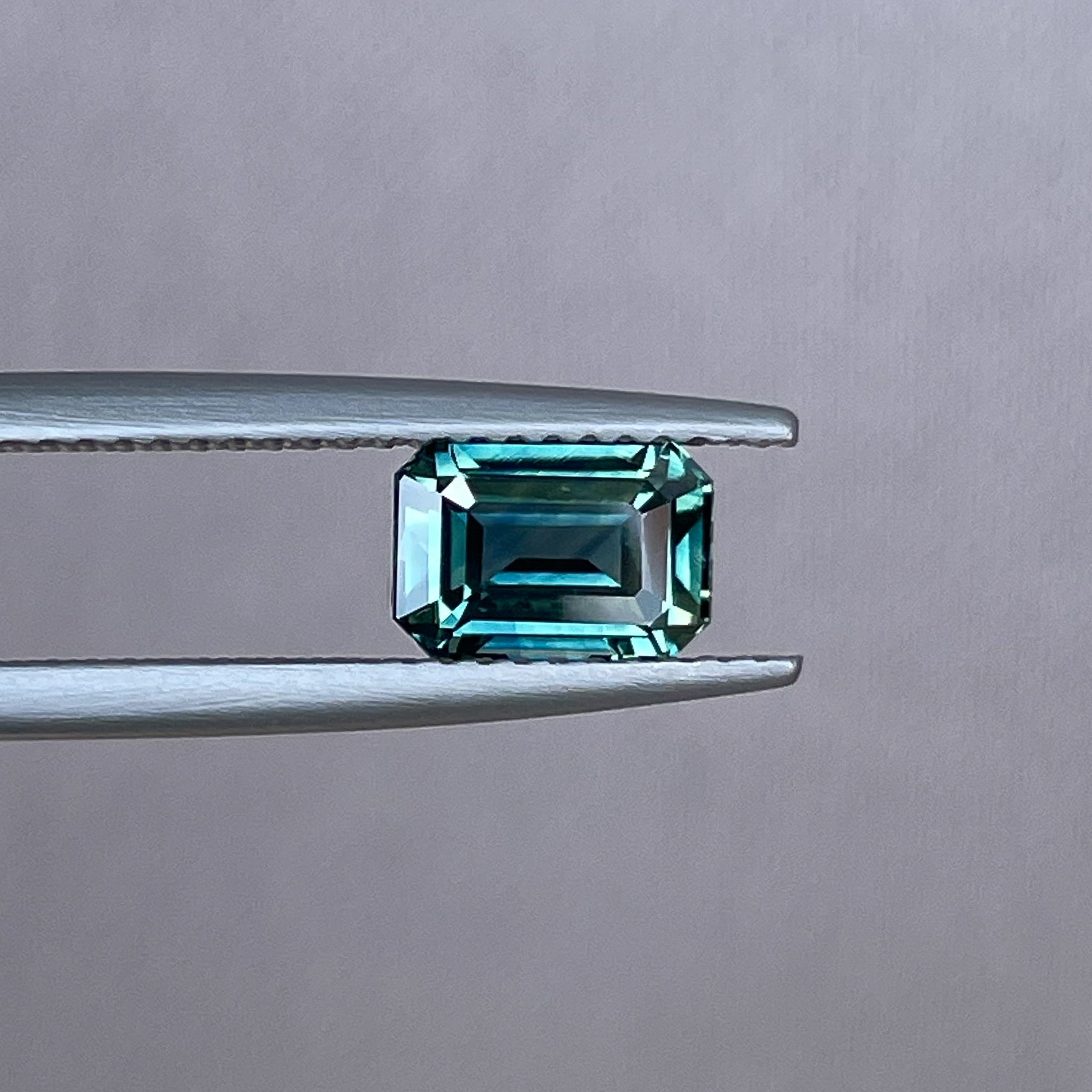 Natural teal sapphire loose gemstone, 1.52 Ct emerald cut in blue-green hues, ideal for engagement rings or custom jewelry.