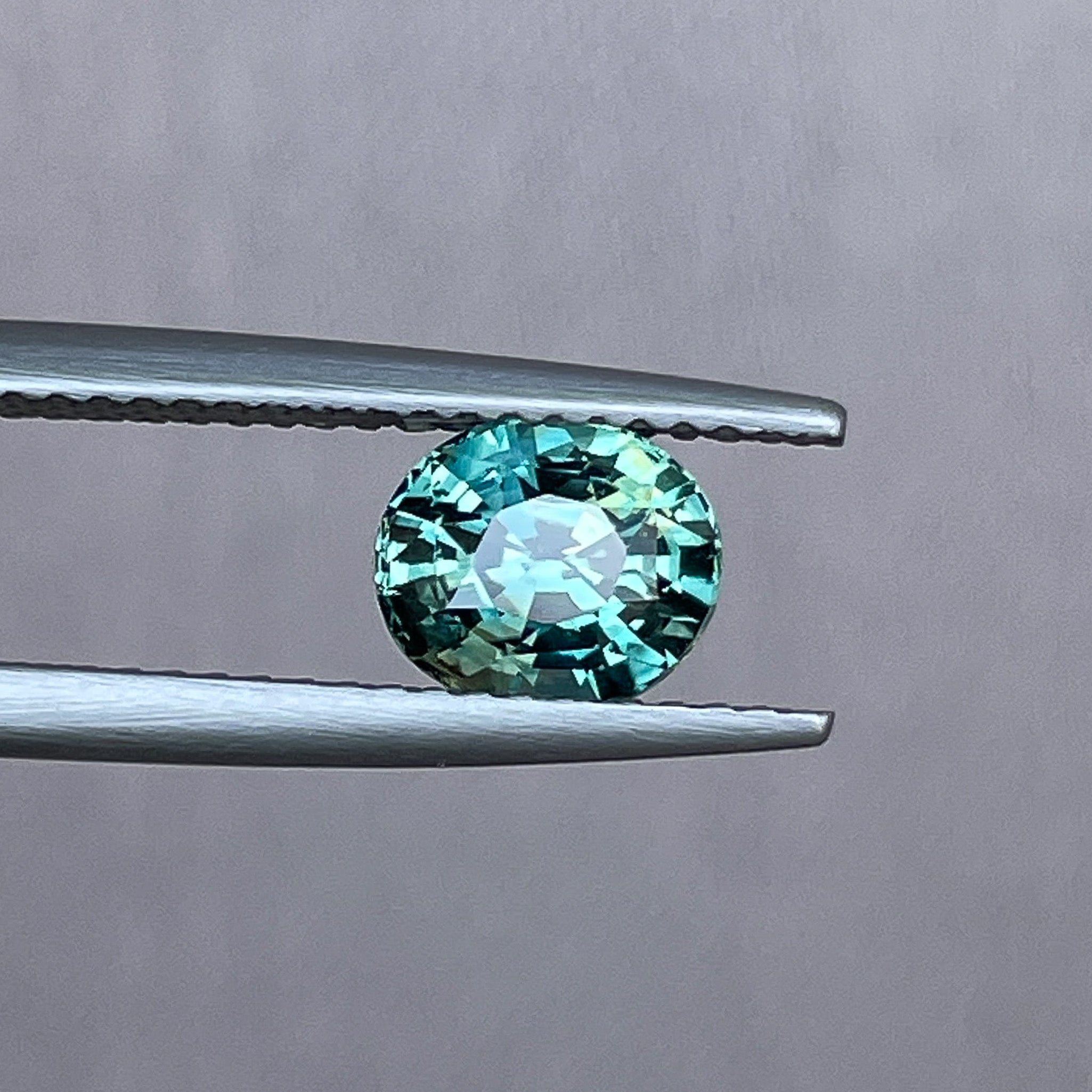 Teal blue green oval cut sapphire gemstone by NASHGEMS, 1.56 carats, suitable for engagement rings or custom jewelry.