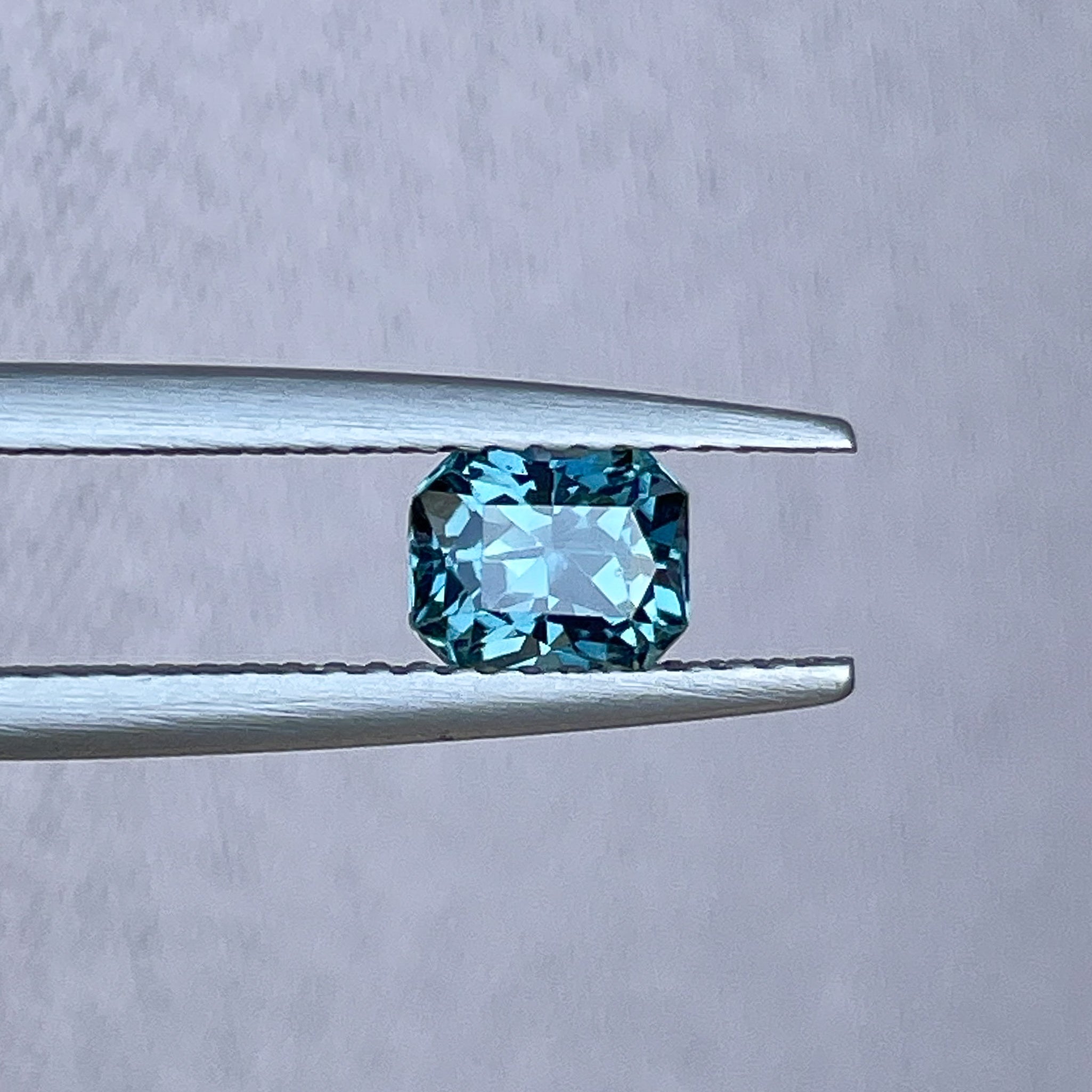 Natural teal blue sapphire 0.98 Ct radiant cut loose gemstone from NASHGEMS, ideal for engagement rings or custom jewelry.