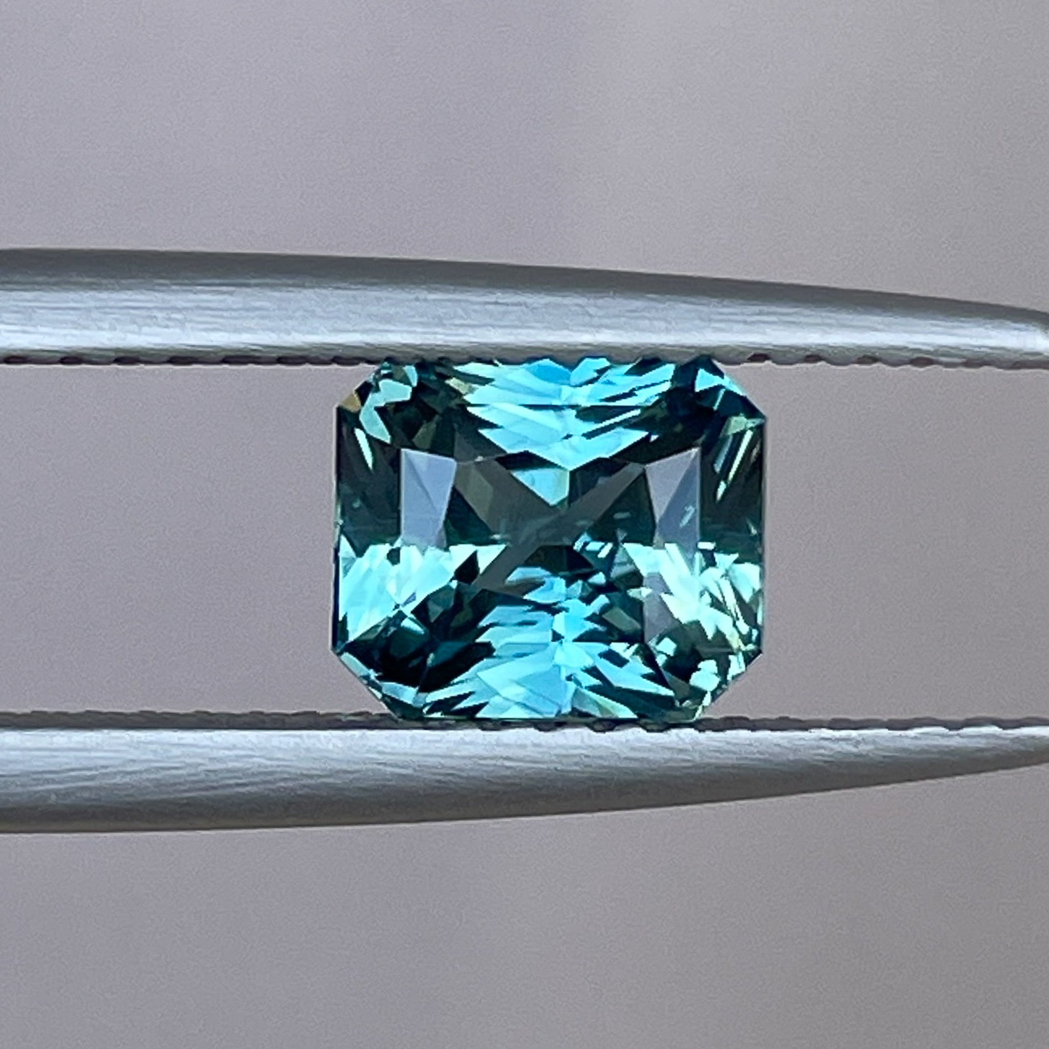 Teal sapphire loose gemstone with radiant cut, 1.73 carats, from NASHGEMS, ideal for engagement rings or custom jewelry.