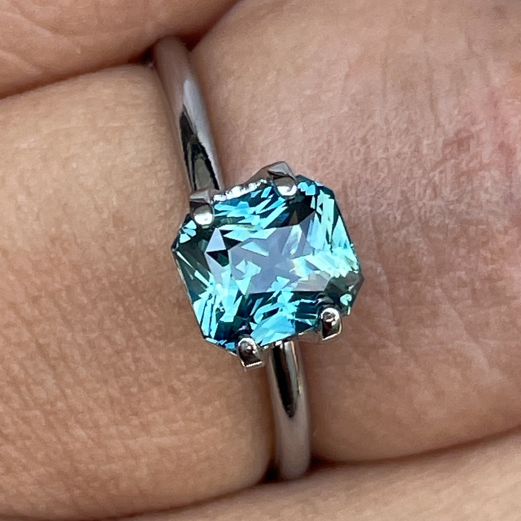 Natural teal sapphire radiant cut 1.73 carats from NASHGEMS, loose gemstone suitable for engagement rings or custom jewelry designs.