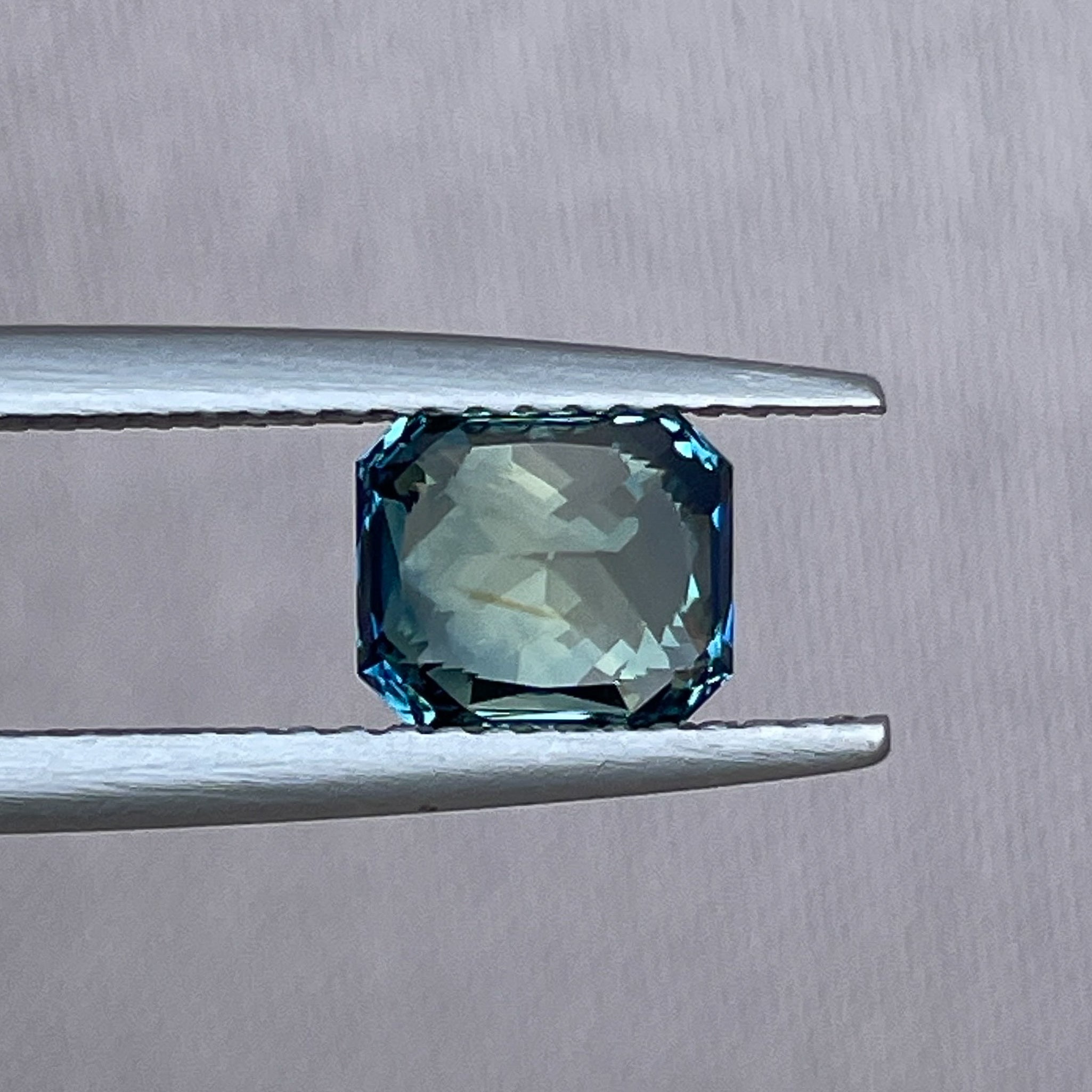 Teal sapphire loose gemstone with 1.65 carats in radiant cut, showcasing vibrant teal blue-green color, from NASHGEMS.