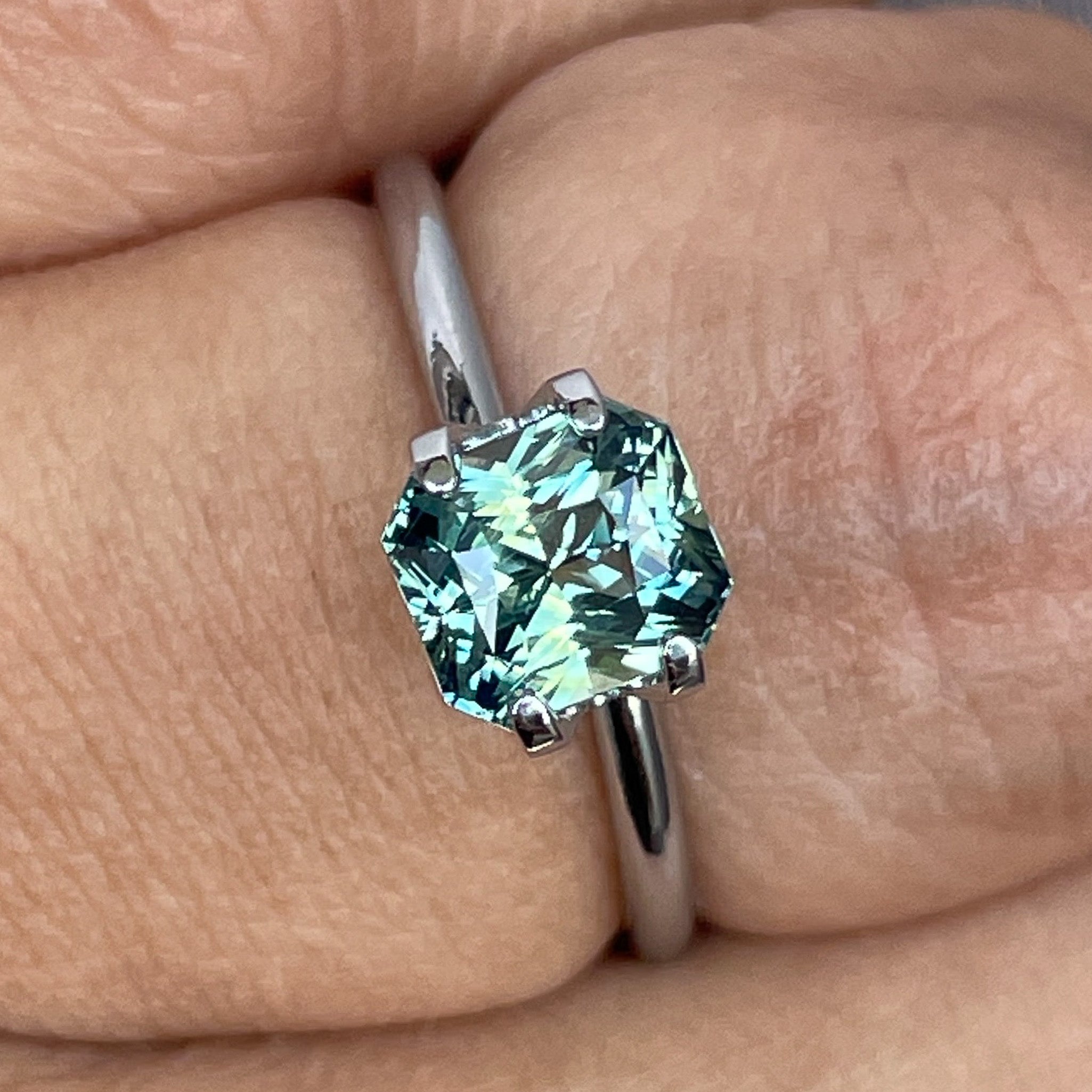 Teal sapphire loose gemstone, 1.65 Ct radiant cut by NASHGEMS, showcasing vibrant blue-green color for engagement rings.