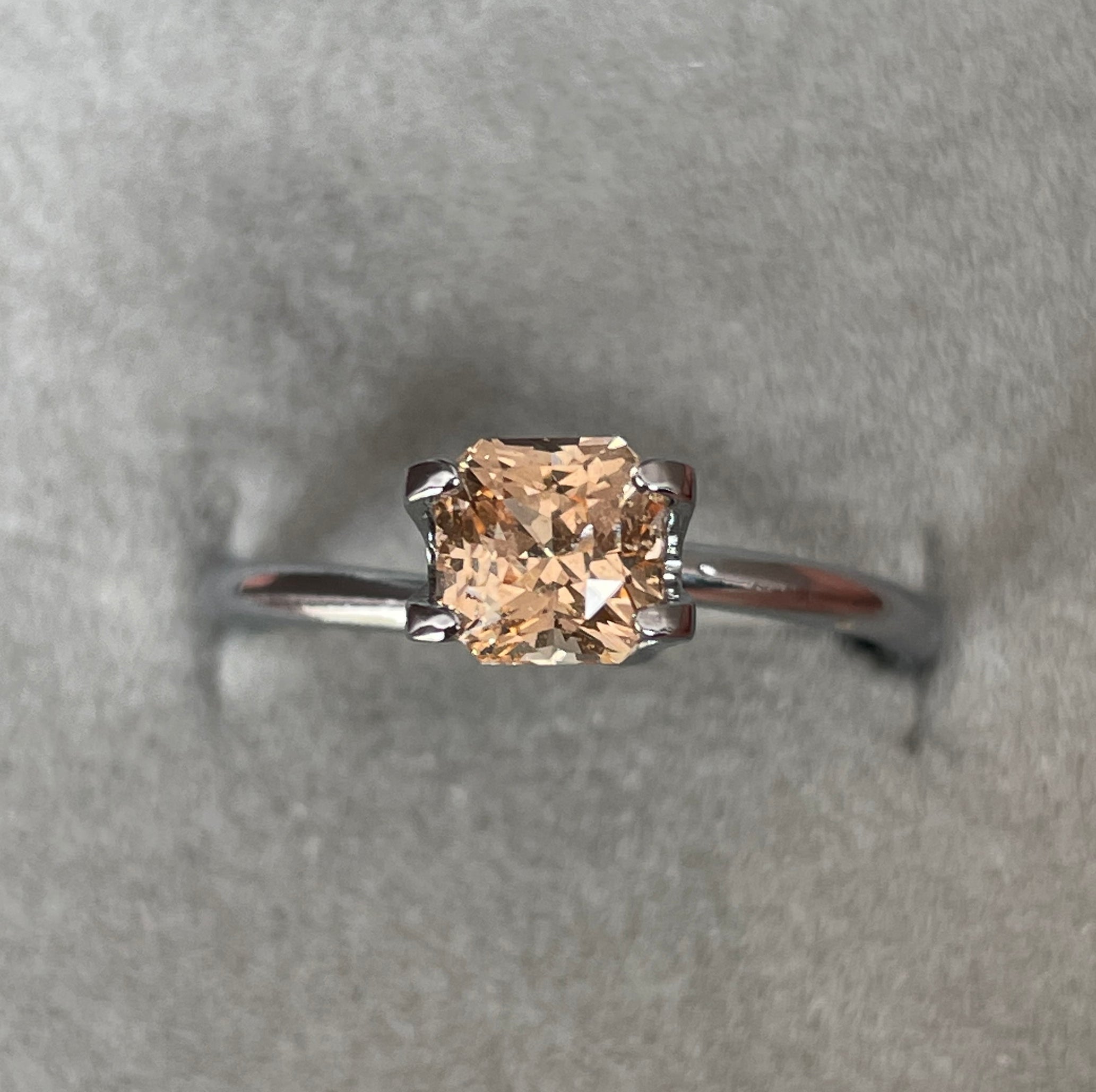 Peach sapphire ring on hand symbolizing love and joy