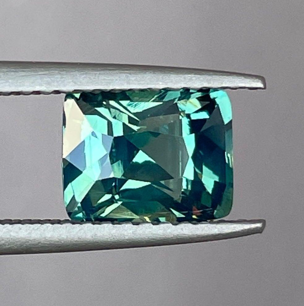 Saphir coussin bleu sarcelle avec des nuances époustouflantes bleu-vert et vert-bleu, idéal pour les bagues de fiançailles par NASHGEMS.