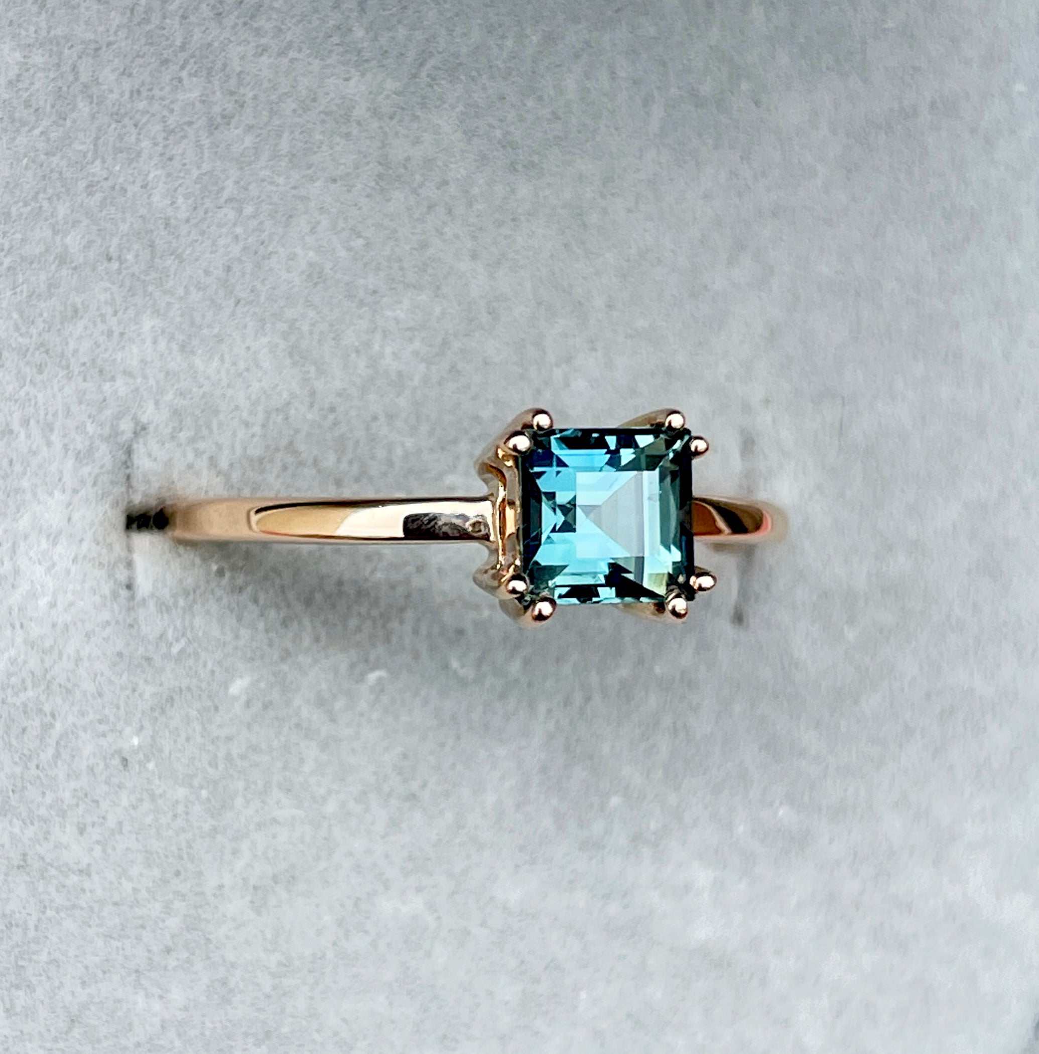 elegant ring features a 1.00 crt  Natural Teal Sapphire surrounded by sparkling natural white sapphire set in a solid 18k Rose Gold ring setting. - NASHGEMS