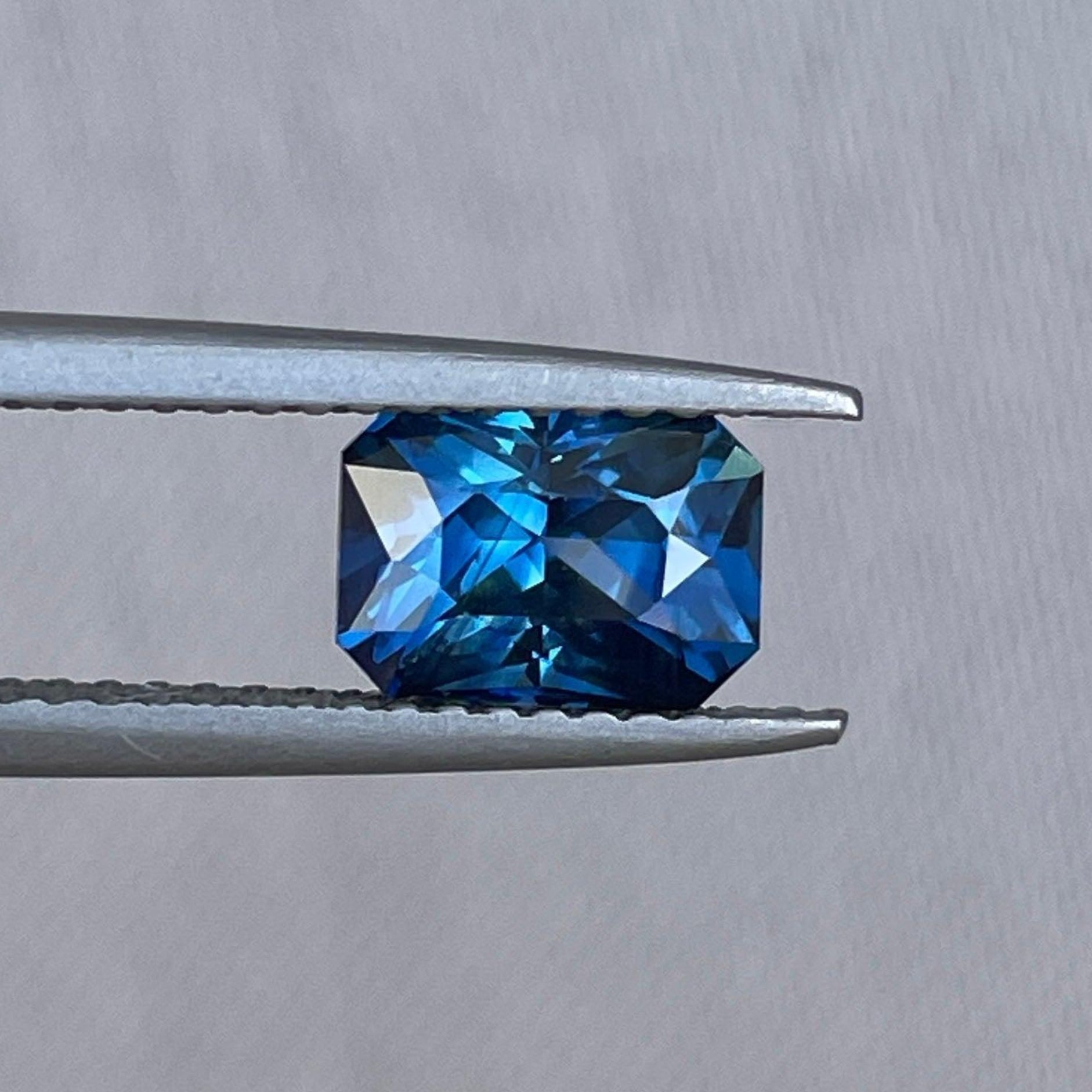 Bague d'anniversaire en saphir sarcelle avec taille radiant, 1,69 carats, présentant un bijou en saphir bleu-vert par NASHGEMS pour une demande en mariage.