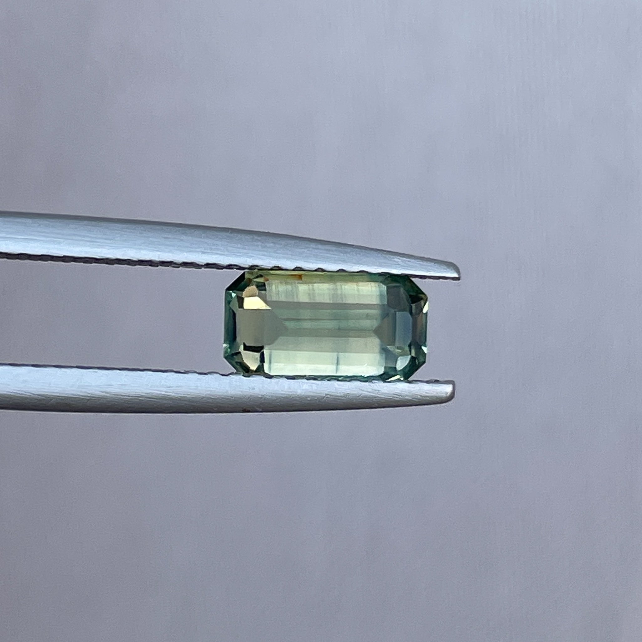 Teal sapphire loose gemstone with emerald cut, 1.49 carats, vibrant green and blue hues, ideal for jewelry making, from NASHGEMS.