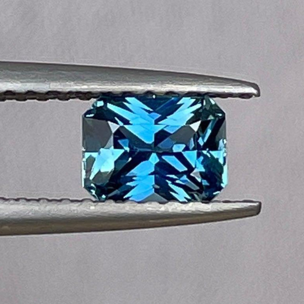 Pierre précieuse saphir teal taillée radiant, 0,84 carat, présentant une couleur teal vibrante idéale pour les bagues de fiançailles ou d'anniversaire.
