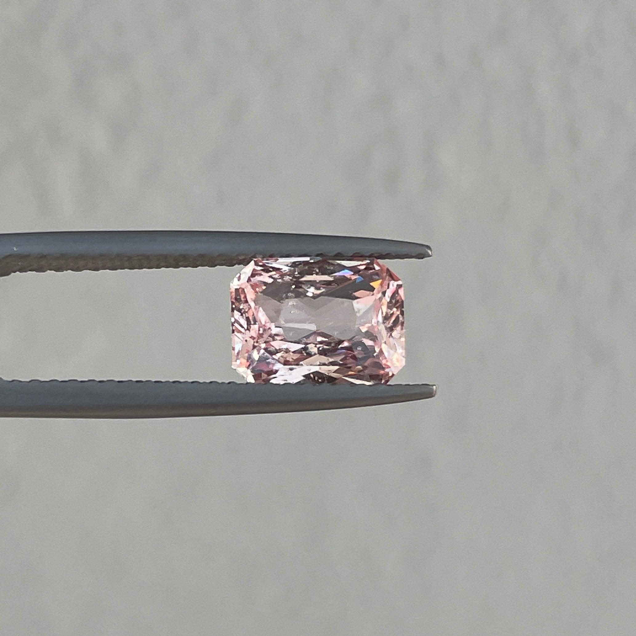 Saphir rose Padparadscha naturel de 2,04 CT de NASHGEMS, mettant en valeur sa couleur vibrante et sa taille lisse.