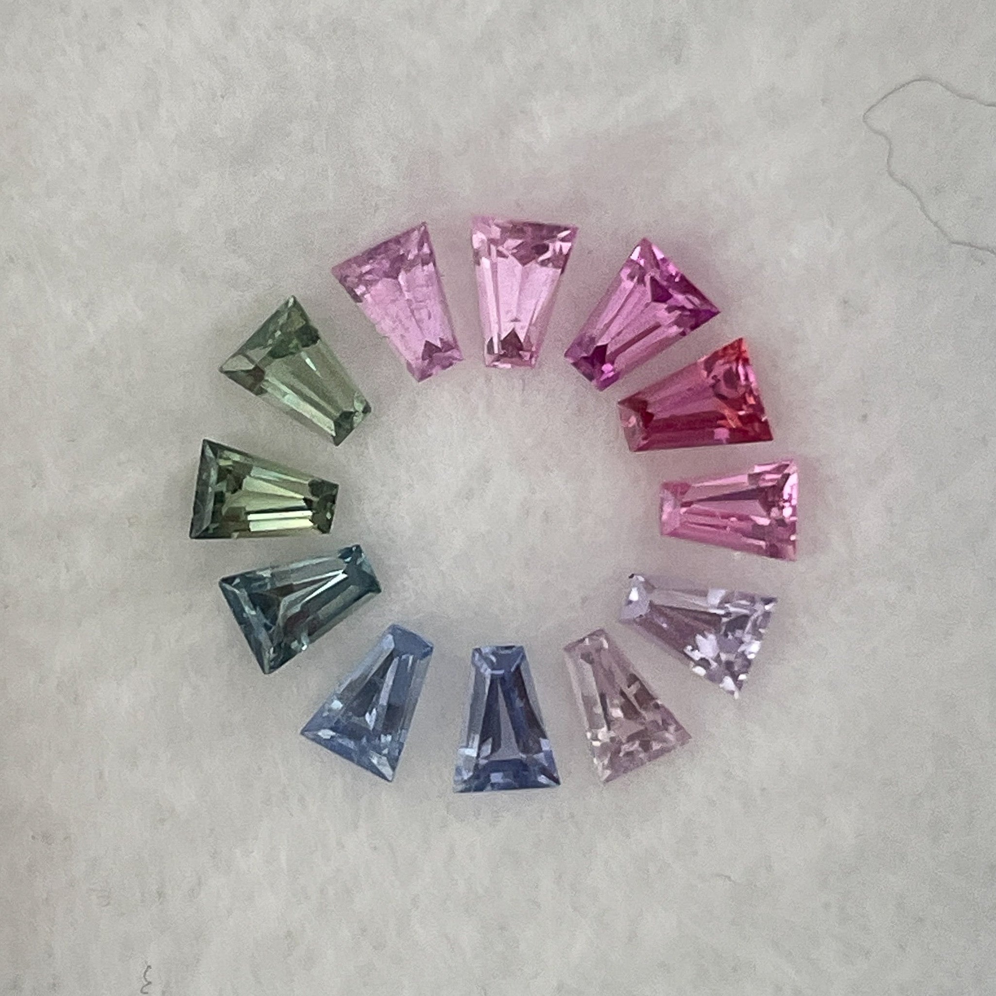 Natural rainbow sapphire lot showing multi-colored loose sapphires totaling 1.37 carats for custom jewelry design.