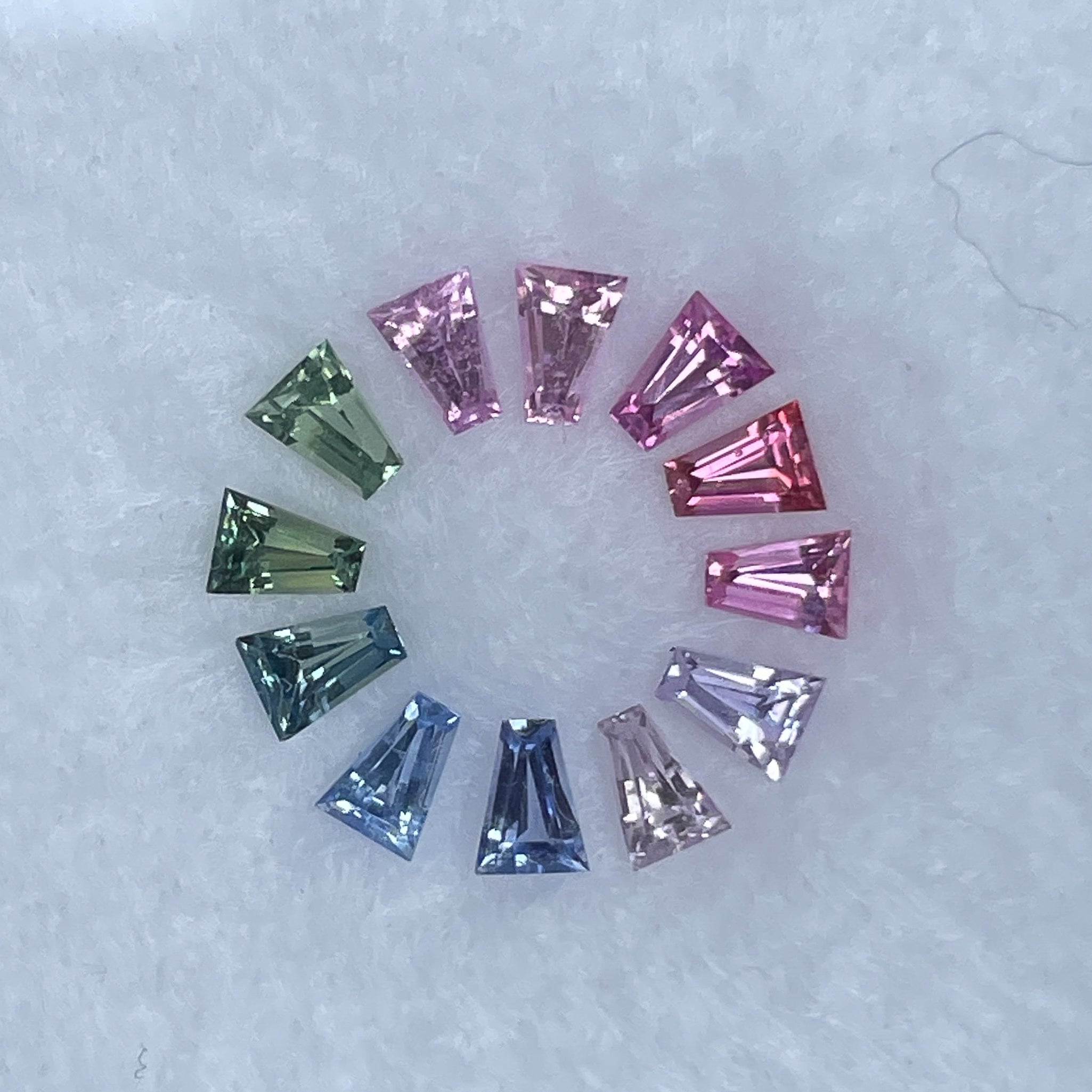 Natural rainbow sapphire lot with multiple multi-colored loose sapphires totaling 1.37 carats for custom jewelry design.