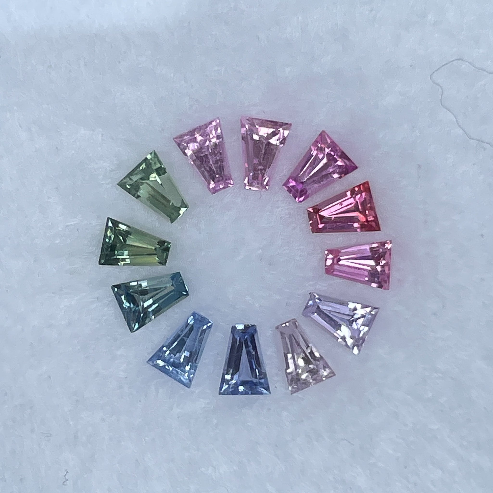 Natural rainbow sapphire lot showing multi-colored loose sapphires totaling 1.37 carats, ideal for custom jewelry design.