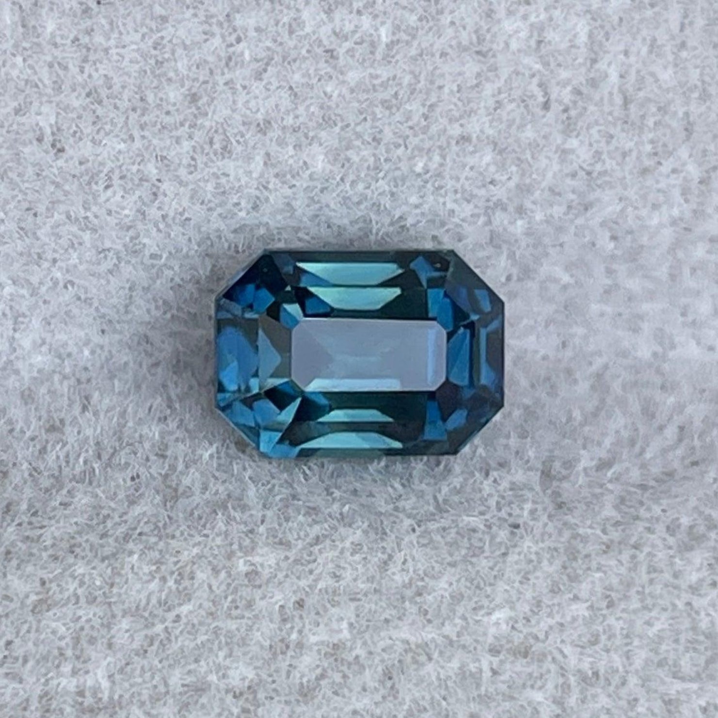 Saphir sarcelle taillé en émeraude, 1,13 carats, de NASHGEMS, présentant des teintes bleu-vert vibrantes et une apparence de pierre précieuse polie.