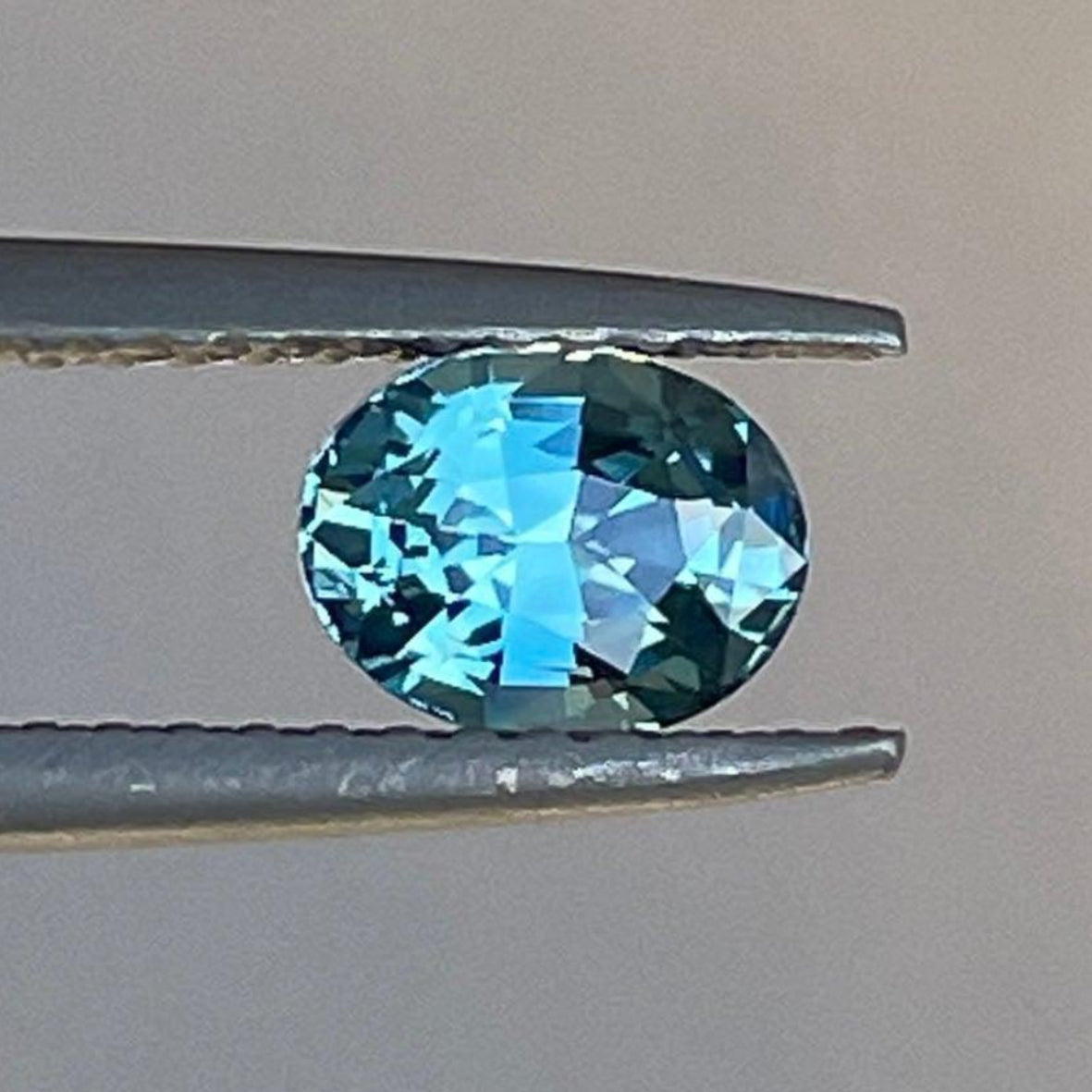 Pierre précieuse saphir sarcelle de NASHGEMS, saphir sarcelle vert caraïbe, 0,97 carat, avec une surface lisse et polie et une couleur vibrante.