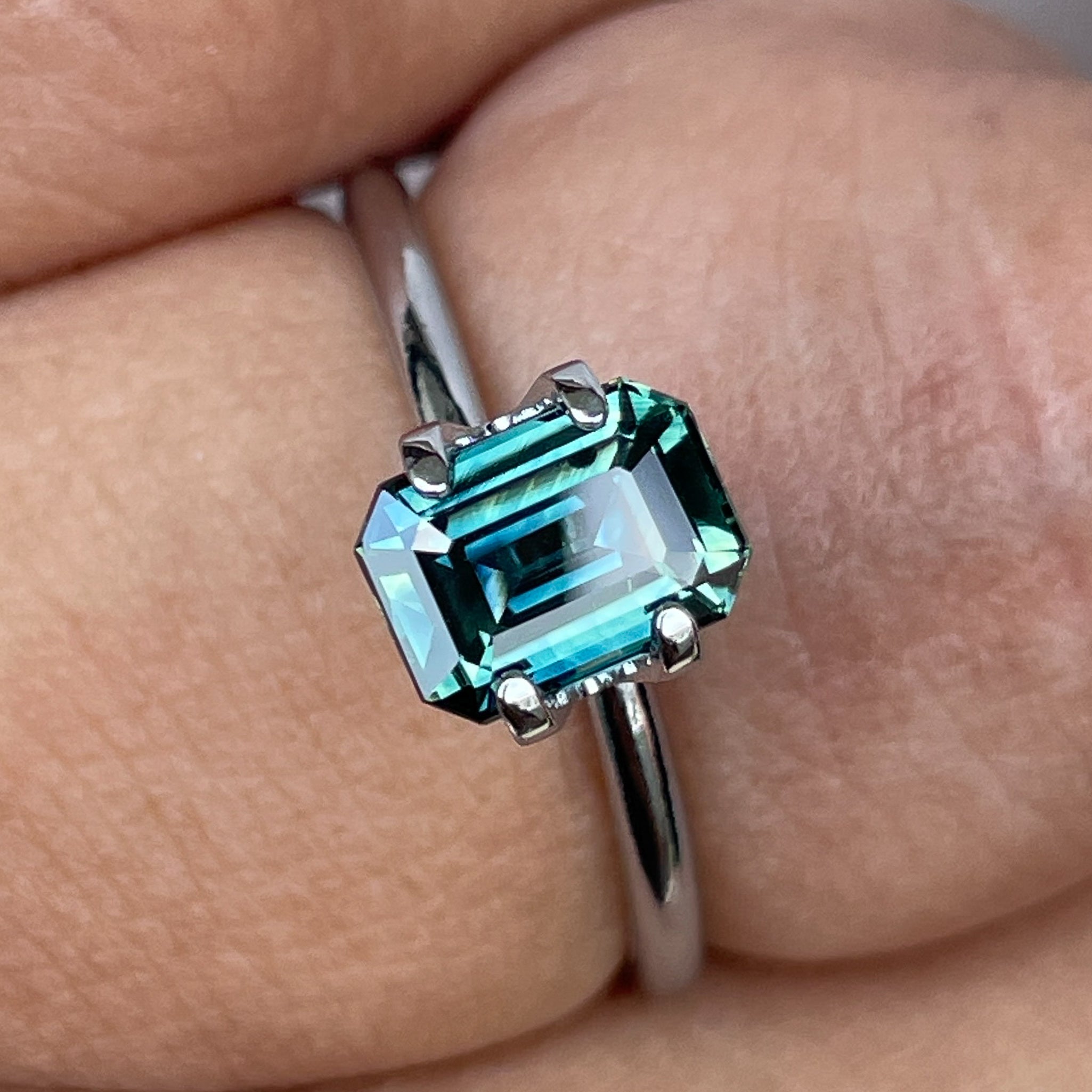 Natural teal sapphire loose stone, 1.52 Ct emerald cut by NASHGEMS, showcasing vibrant blue-green hues for jewelry making.