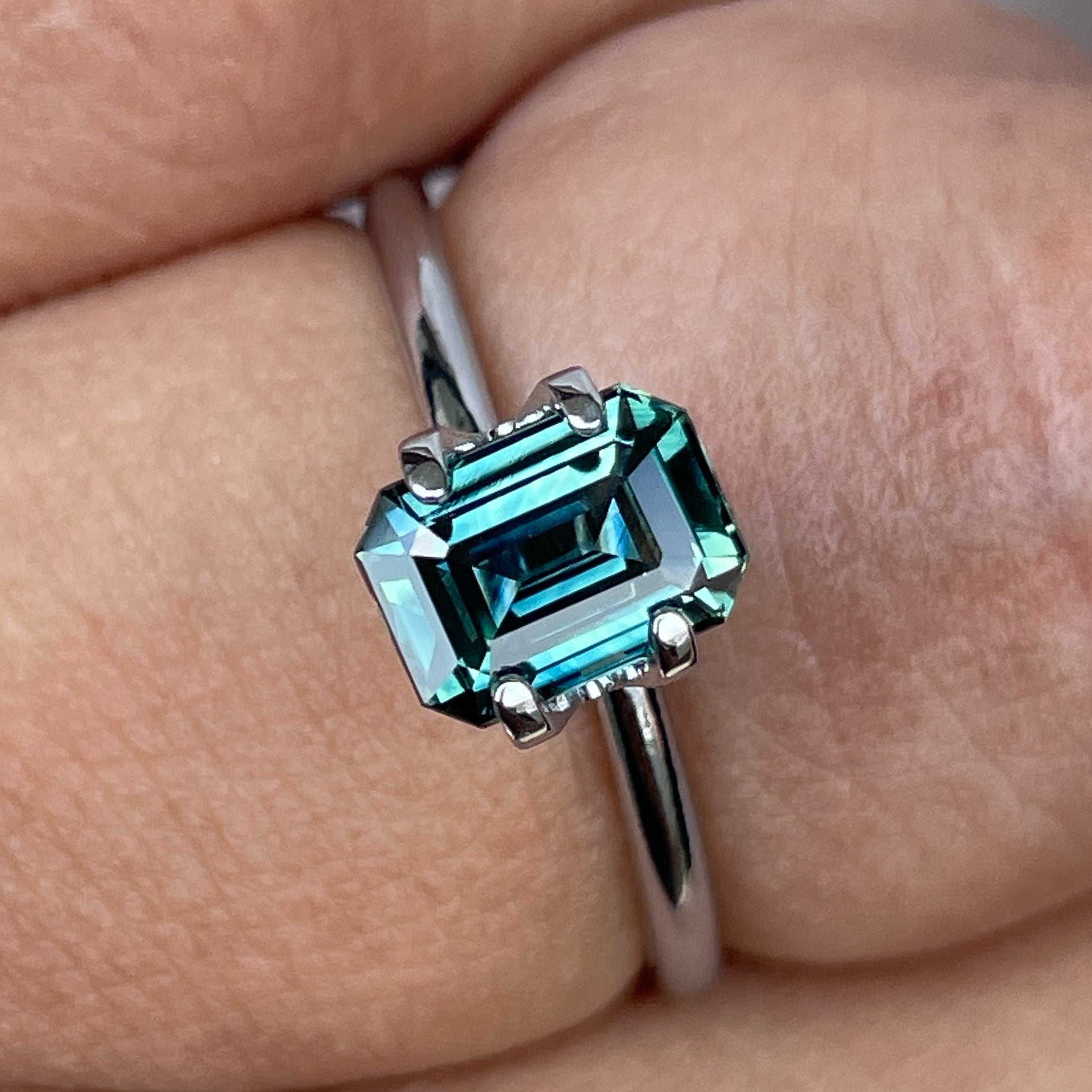Natural teal sapphire loose stone, 1.52 ct emerald cut by NASHGEMS, showcasing vibrant blue-green hues for jewelry or engagement rings.