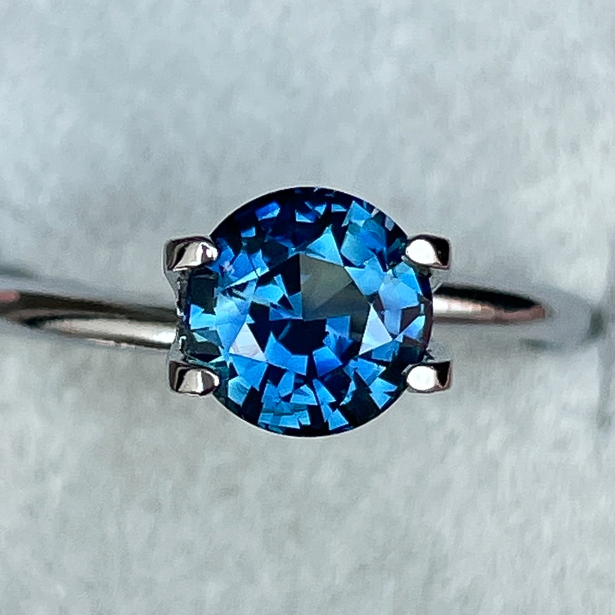 Natural teal blue sapphire, 1.65 carats, round cut, loose gemstone from NASHGEMS for engagement or custom jewelry.