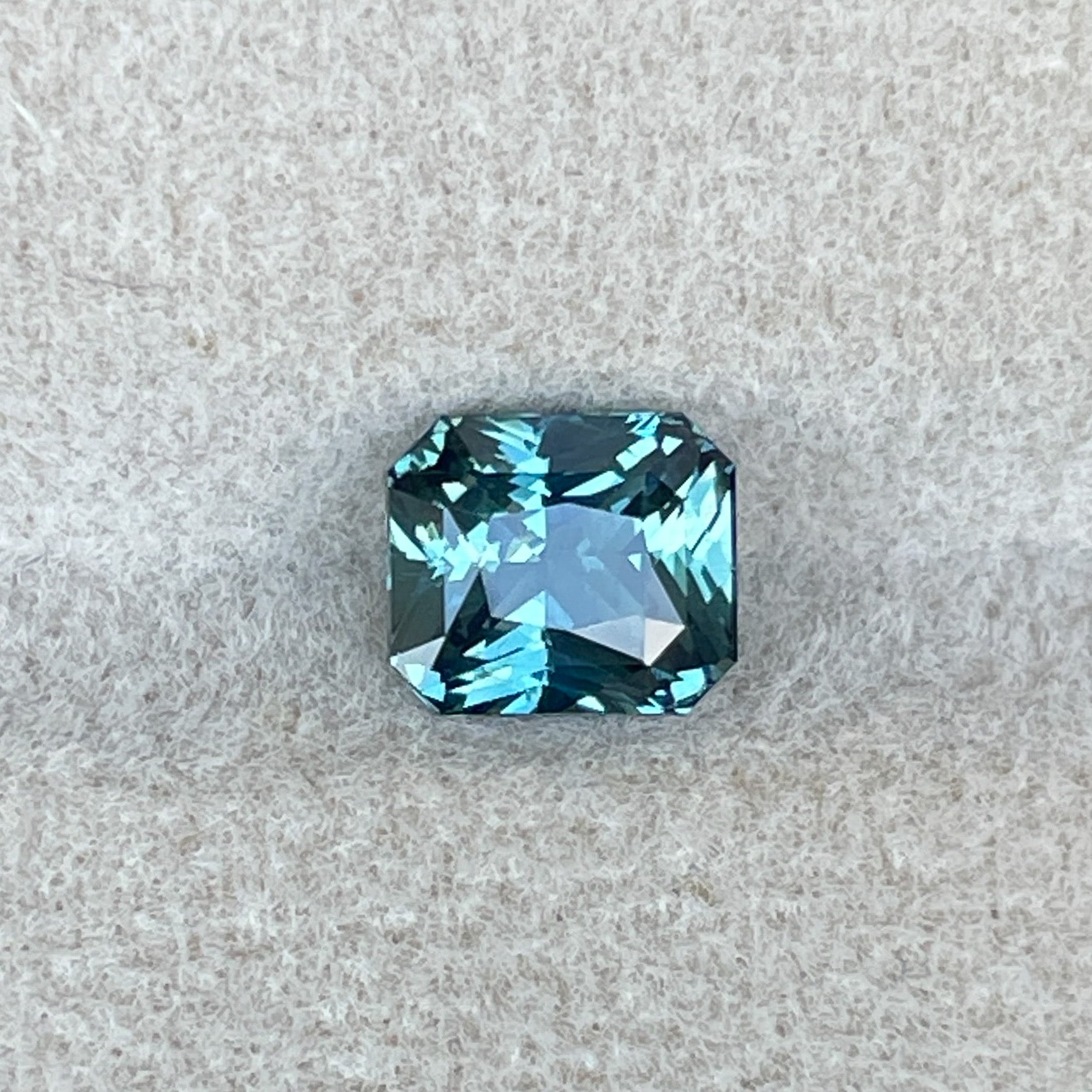 Natural teal sapphire radiant cut 1.73 ct by NASHGEMS, loose gemstone perfect for engagement rings or custom jewelry.