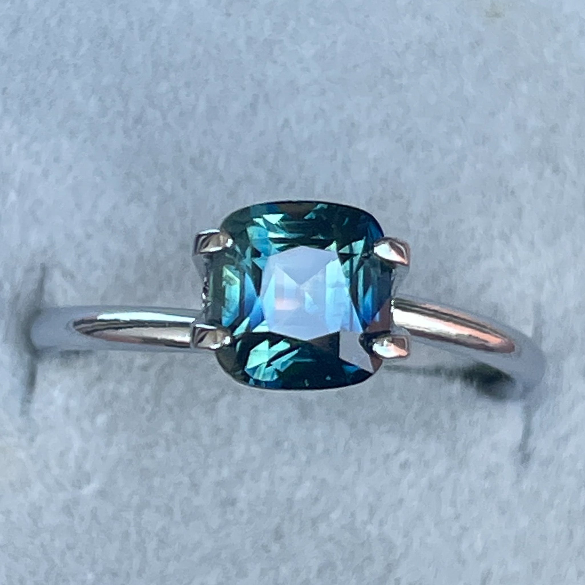 Natural blue-green sapphire cushion cut 2.14 ct from NASHGEMS, showcasing vibrant teal color and brilliant gemstone details.