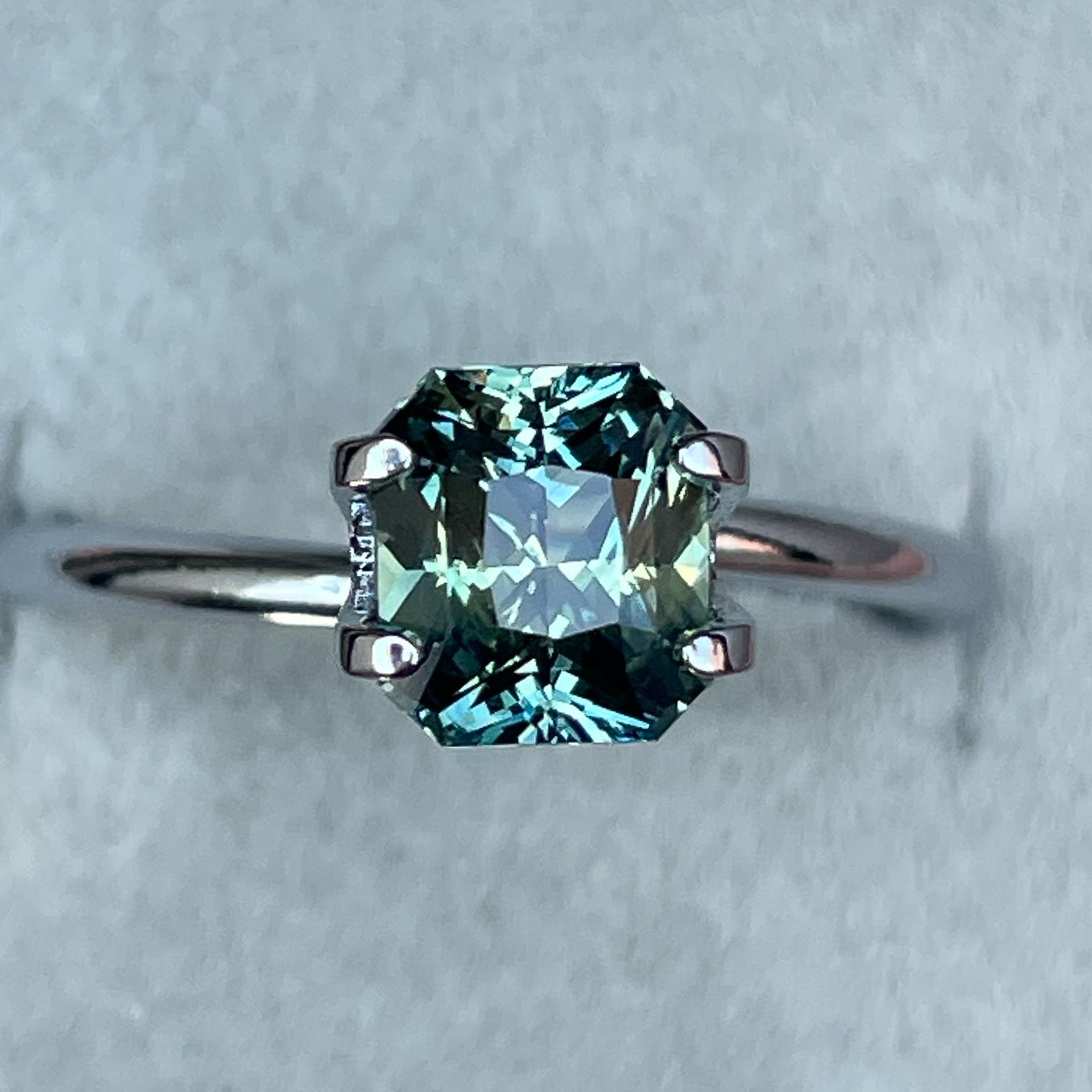 Teal sapphire loose gemstone in radiant cut, 1.65 Ct, showing vibrant teal blue-green color, from NASHGEMS for engagement jewelry.