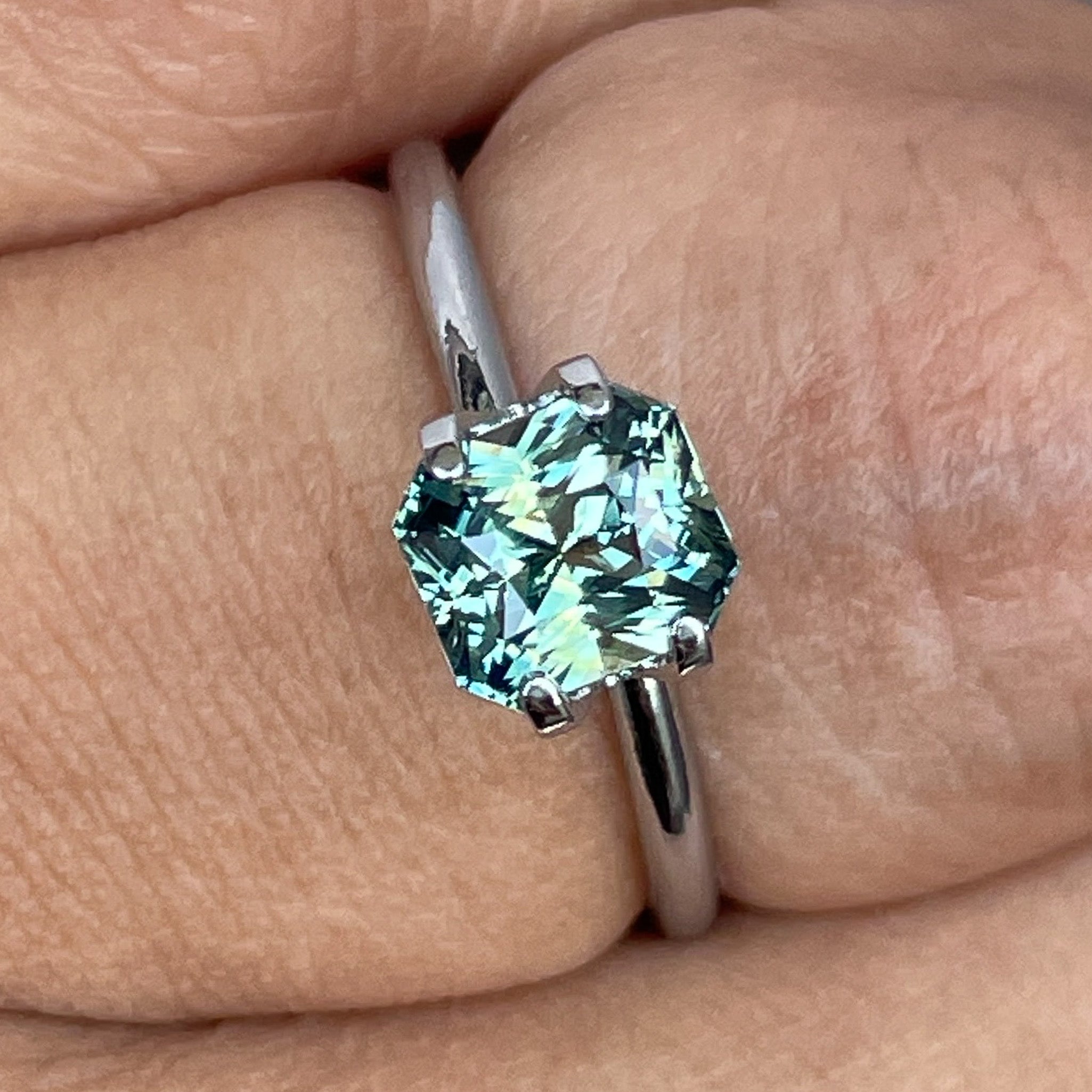 Teal sapphire loose gemstone with radiant cut, 1.65 carats, from NASHGEMS, showcasing vibrant teal blue-green color and clarity.